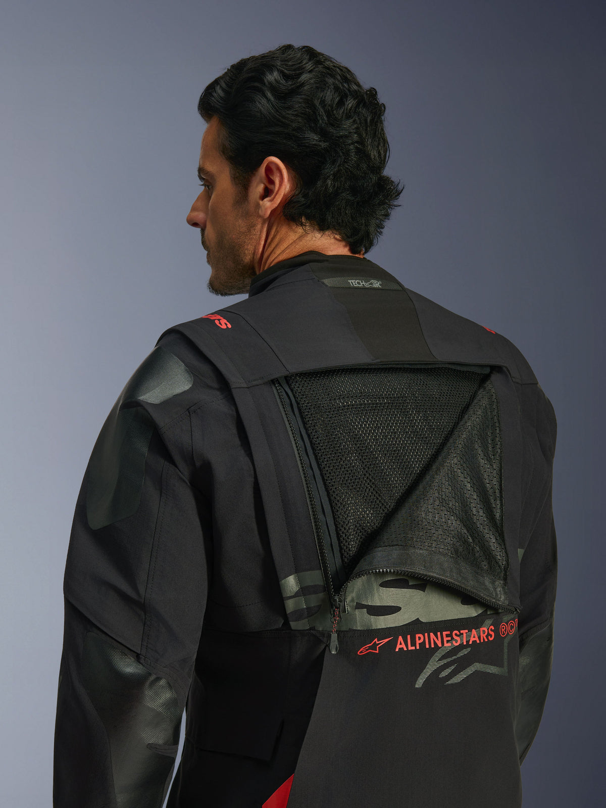 Alpinestars Halo Pro Drystar® XF Laminated Jacket, motocyklowa kurtka adventure, Black Dark Shadow, widok z tyłu przedstawiający rozpięty modułowy panel wentylacyjny odsłaniający dużą powierzchnię z siatki, czerwone logo Alpinestars, logo Tech-Air® Ready na kołnierzu, wytrzymała tekstylna konstrukcja do jazdy w każdym terenie