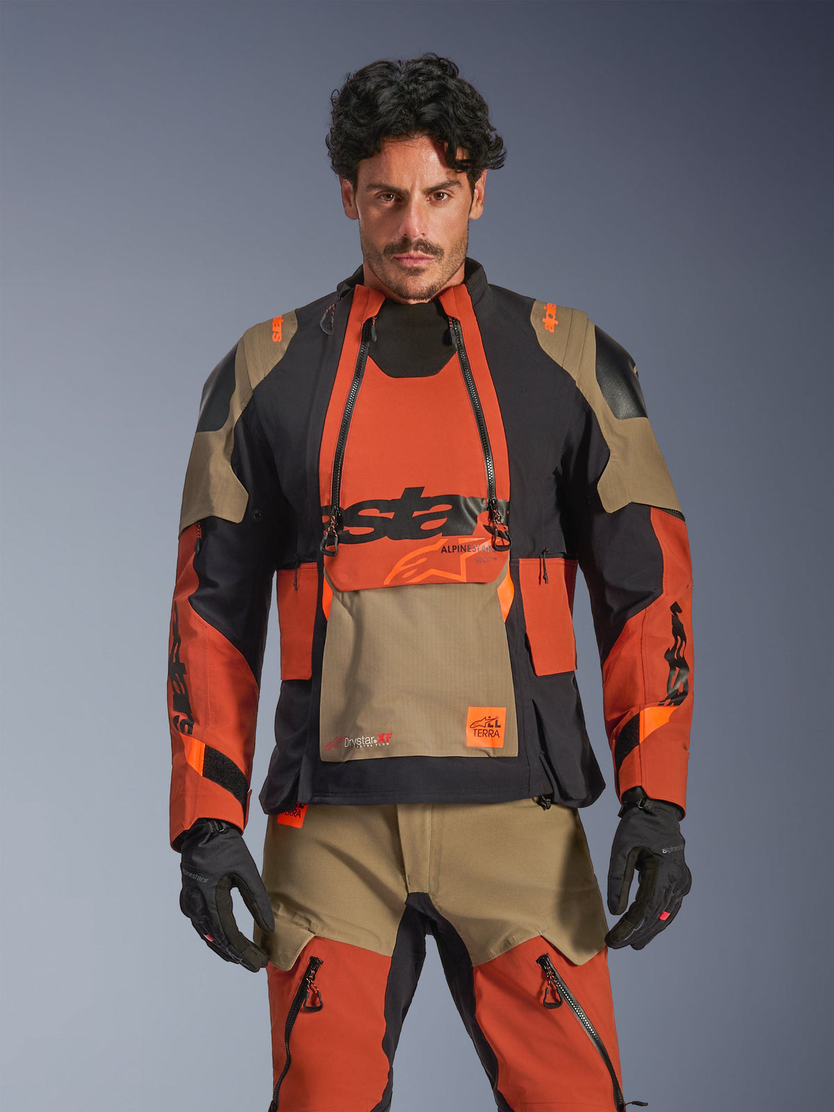 Alpinestars Kurtka Halo Pro Drystar® XF Laminowane, kurtka motocyklowa adventure w kolorze rdzawo-brązowym, czarnym i piaskowym, widok z przodu na model prezentujący wodoodporną laminowaną konstrukcję i modułową wentylację