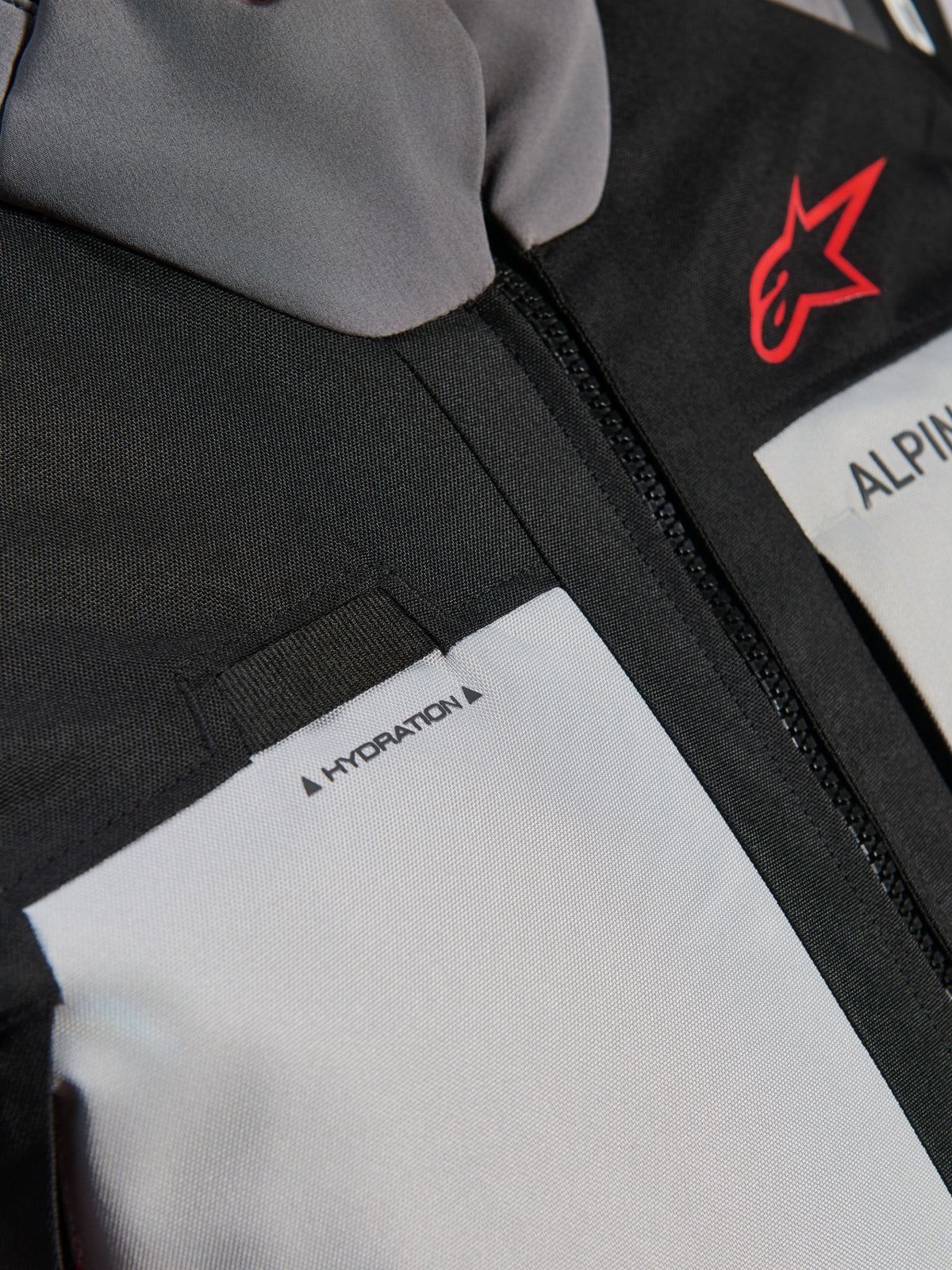 Alpinestars Andes V4 Drystar® Jacket, close-up detail of the chest, Dark Gray and Ice Gray panels with black textile reinforcements, featuring a red Alpinestars logo and a hydration hose loop with 'HYDRATION' label