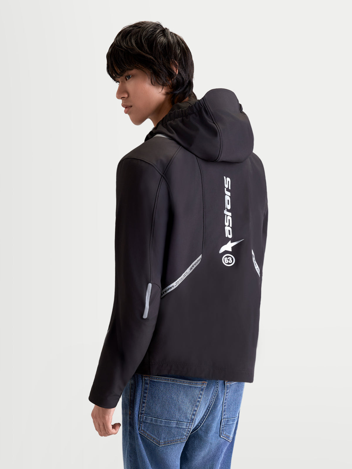 Alpinestars C 5 Drystar kurtka motocyklistyczna miejska męska, czarna, widok z tyłu na modelu prezentujący zintegrowany kaptur, odblaskowe detale oraz pionowe logo z tyłu
