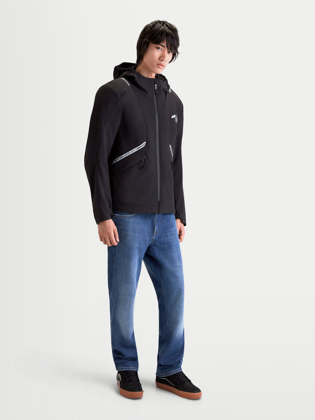 Alpinestars C-5 Drystar, męska miejska kurtka motocyklowa w kolorze czarnym, noszona przez modela, z wodoodporną konstrukcją softshell, zintegrowanym kapturem i odblaskowymi detalami