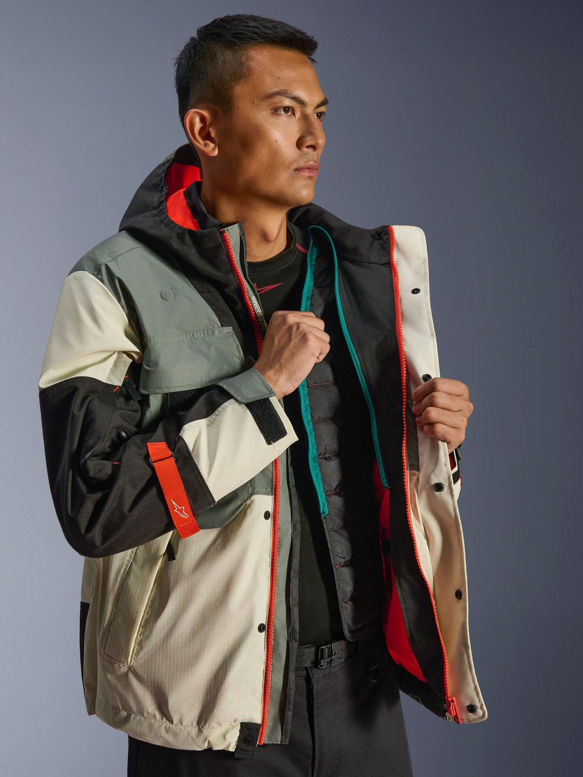 Alpinestars Mospher Waterproof Jacket, miejska parka motocyklowa, kolor Fur Gray Black Ice, kremowe i szare panele z jaskrawopomarańczowymi akcentami, pokazana rozpięta z pikowaną kamizelką termiczną, design inspirowany stylem taktycznym do jazdy w każdych warunkach pogodowych