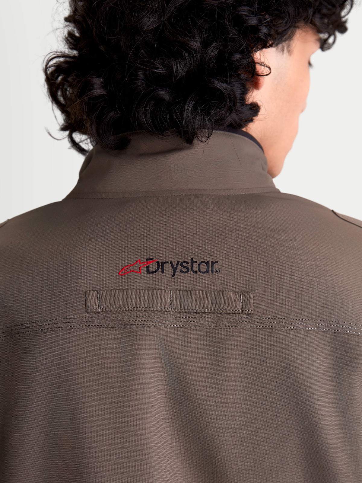 Alpinestars Altan Drystar kurtka motocyklowa męska miejska współczesna, orzechowa i czarna, zbliżenie na tył pokazujące zintegrowany ciepły kołnierz, branding Drystar na plecach oraz trwale wykonaną konstrukcję z tkaniny poliestrowej