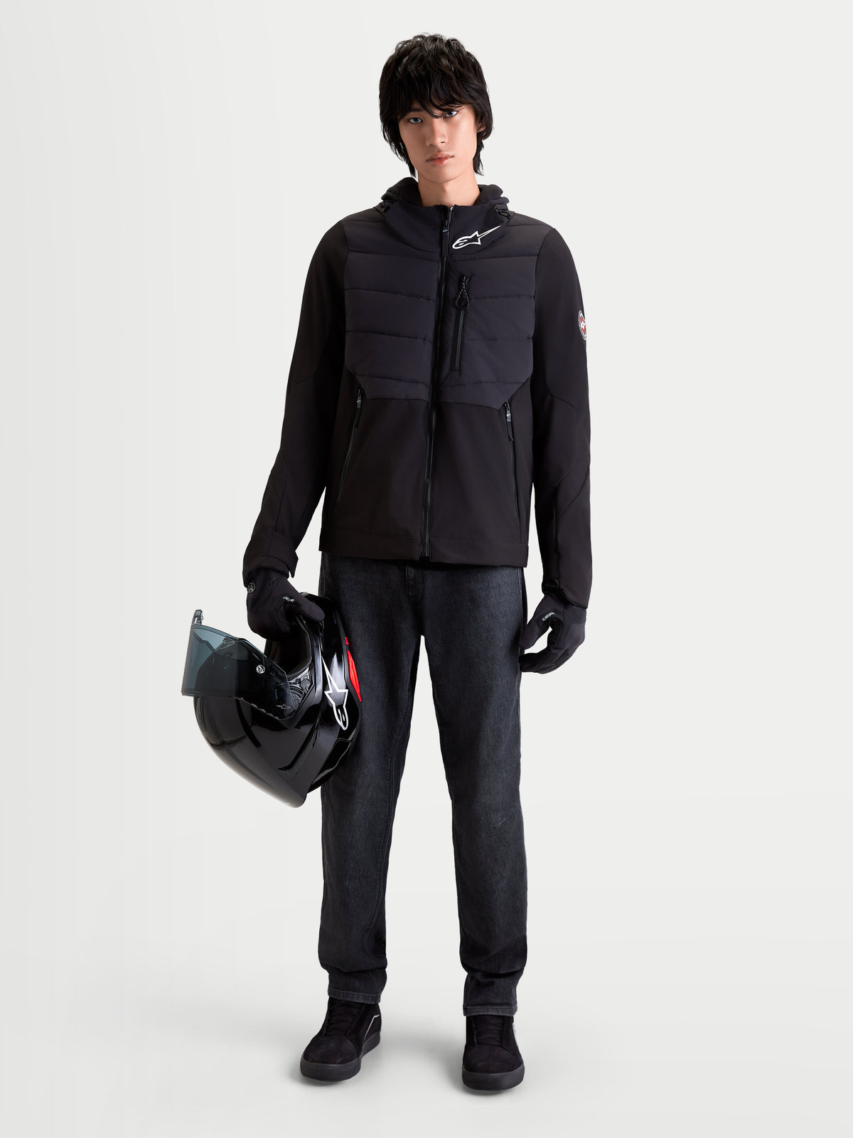 Alpinestars Therma Tech WP kurtka motocyklowa miejska męska, czarna, widok z przodu na model w pasujących rękawicach trzymający kask, z konstrukcją pikowaną i materiałem softshell