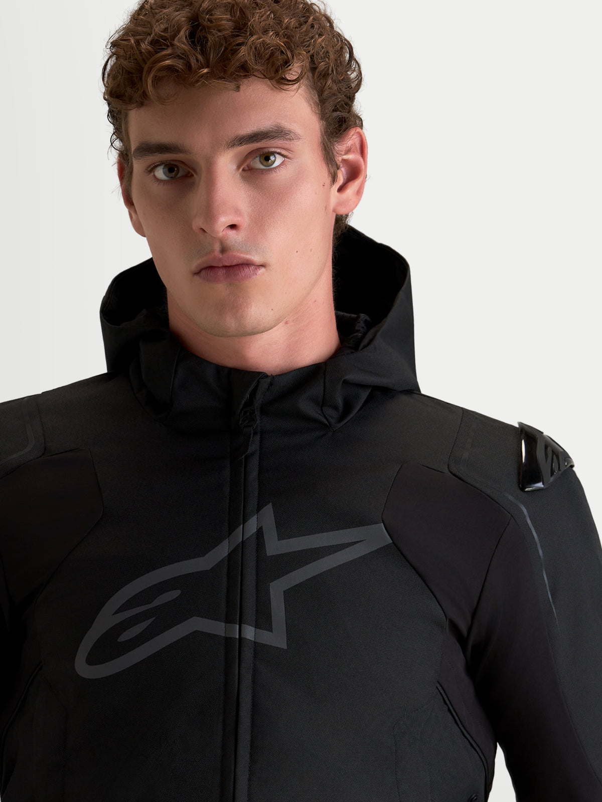 Alpinestars Zaca V2 Waterproof, męska czarna kurtka motocyklowa z ochraniaczami ramion DFS i zintegrowanym kapturem, portret na modelu
