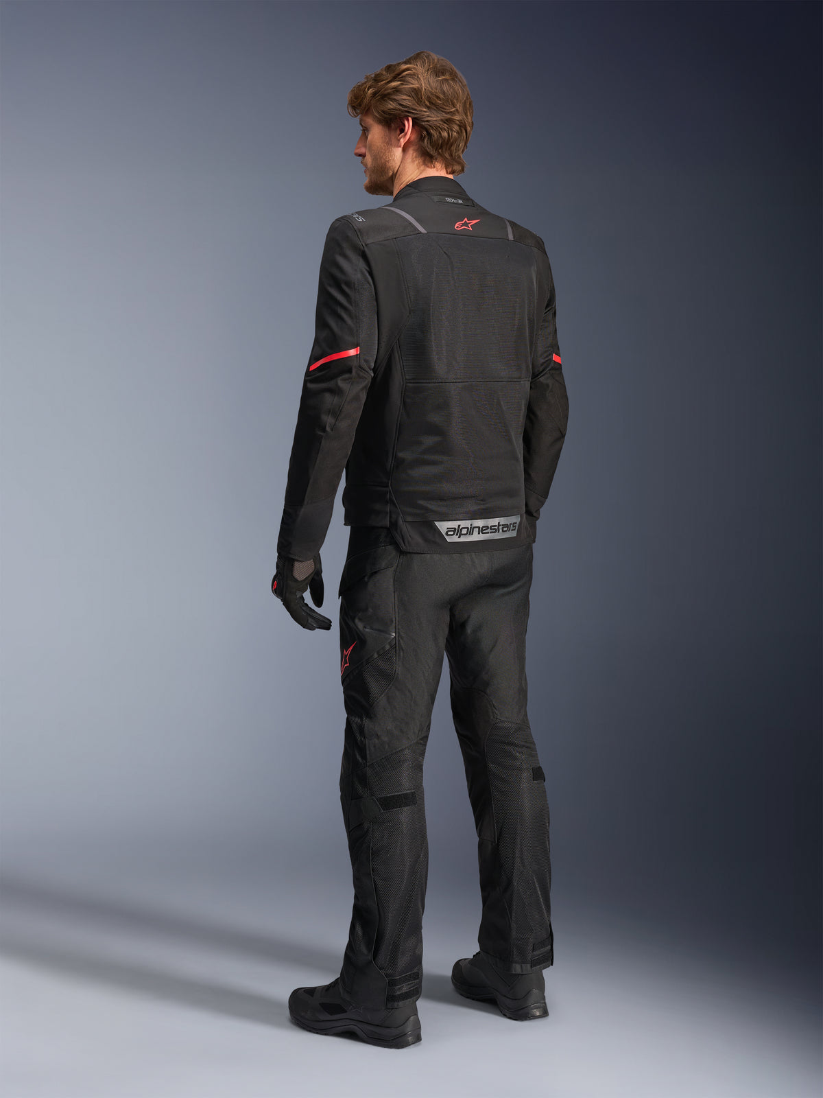 Alpinestars ST-2 Air Jacket, męska kurtka motocyklowa adventure touring, czarna, widok z tyłu, panele z siatki i czerwone logo.
