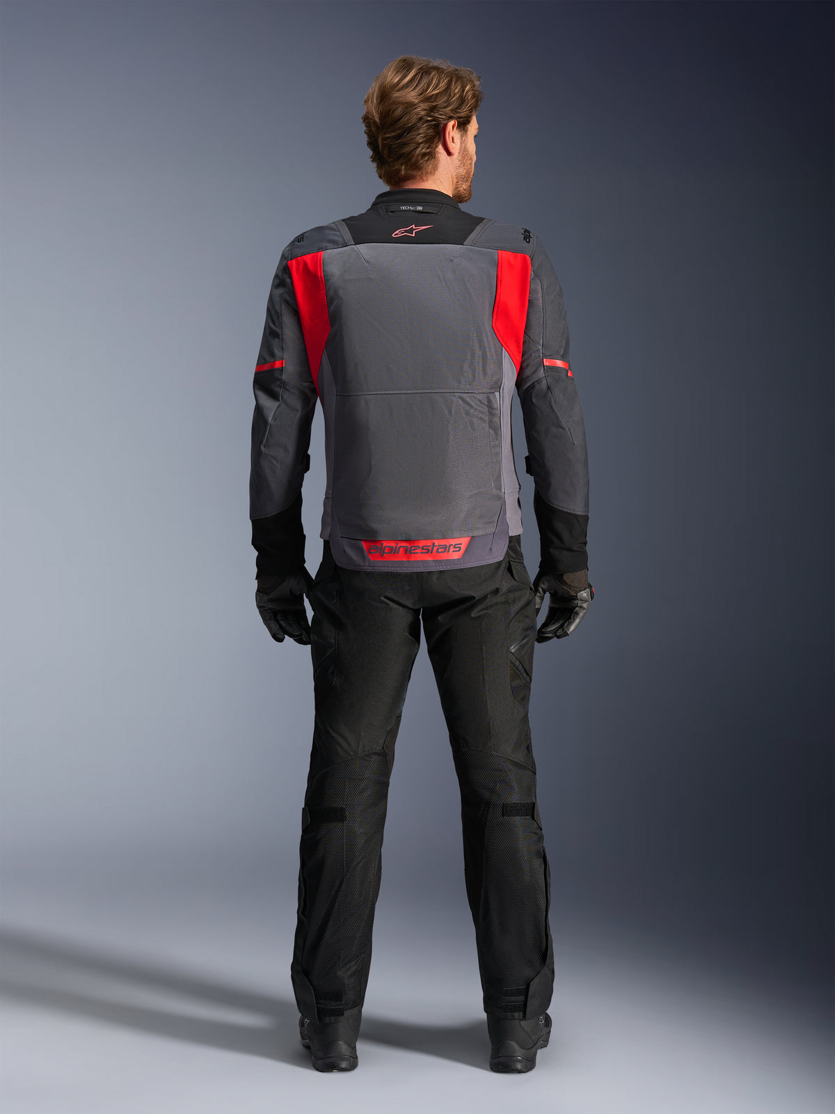 Kurtka motocyklowa Alpinestars ST-2 Air, męska, turystyczna, szara i czerwona, widok z tyłu z siatkową wentylacją.