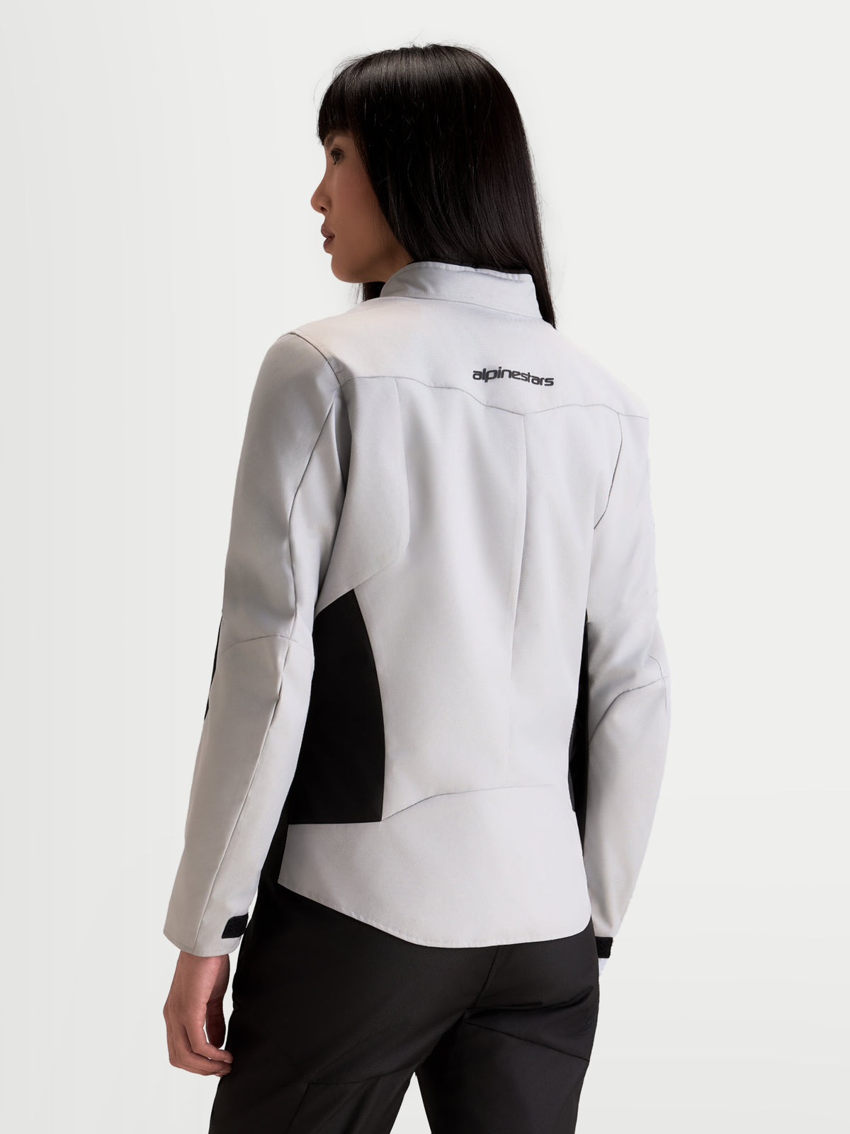 Alpinestars Stella C-1 Waterproof Kurtka motocyklowa damska miejska w kolorze szarym lodowym i czarnym, widok z tyłu na modelkę przedstawiający konstrukcję pleców 3D oraz logo marki na górnej części pleców