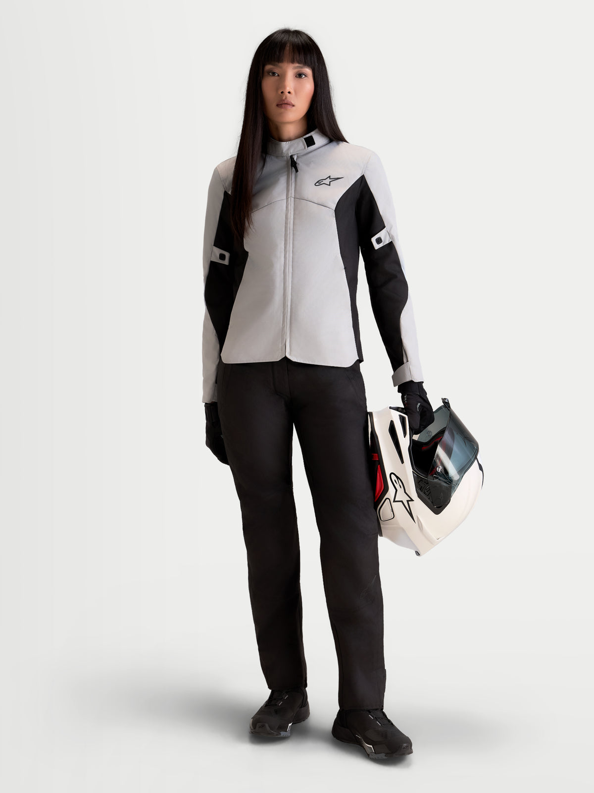 Alpinestars Stella C-1 Waterproof Kurtka motocyklowa damska urban, szaro-czarna, widok z przodu na modelkę trzymającą pasujący kask, odzież tekstylna do codziennych dojazdów