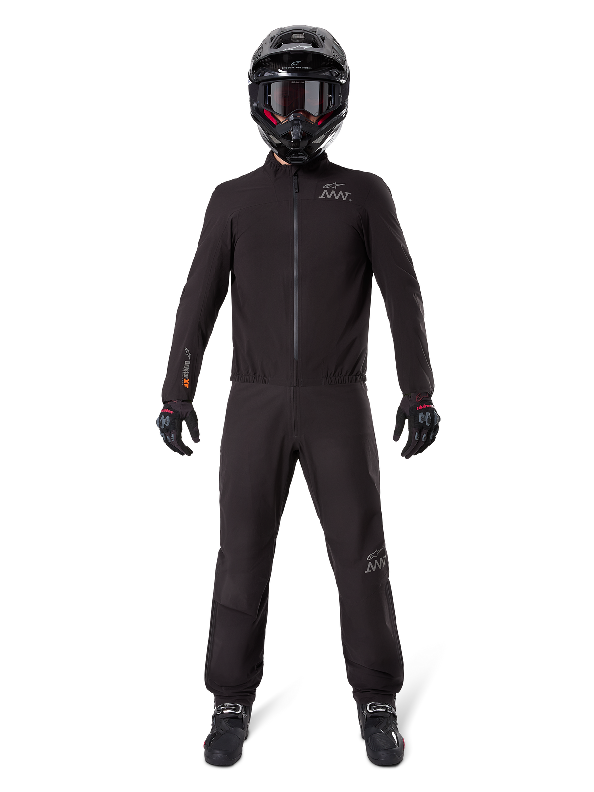 Motocyklista ubrany w podszewkę spodni Alpinestars AMT-8 Stretch Drystar® XF i pasującą kurtkę, czarny wodoodporny i wiatroszczelny strój techniczny, czarny kask, rękawice i buty, elegancki design adventure touring