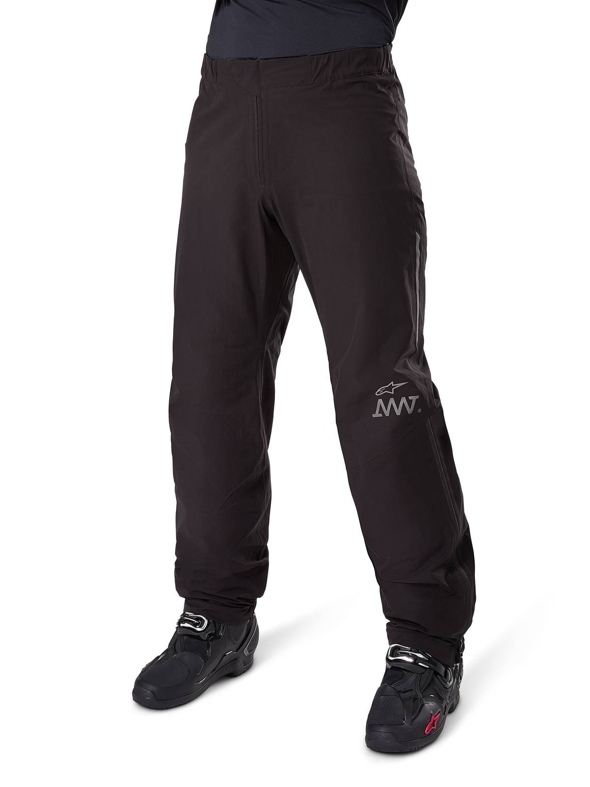 Alpinestars Amt-8 Stretch Drystar® XF Pant Liner, czarna, wodoodporna i elastyczna konstrukcja tekstylna ze srebrnym logo AMT, noszona z czarnymi butami motocyklowymi, element odzieży adventure touring.