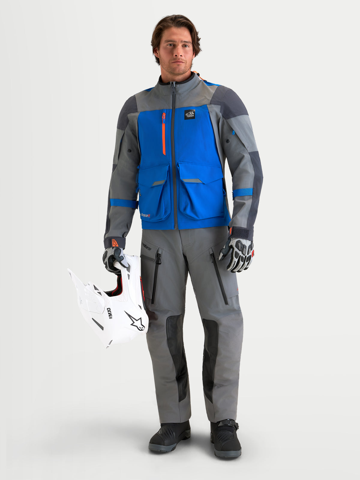 Alpinestars Maxdura Drystar®XF Laminated Pants, Men's adventure motorcycle pants in Dark Gray and Black, CE Level 2 knee protection, worn by a model holding a white off-road helmet