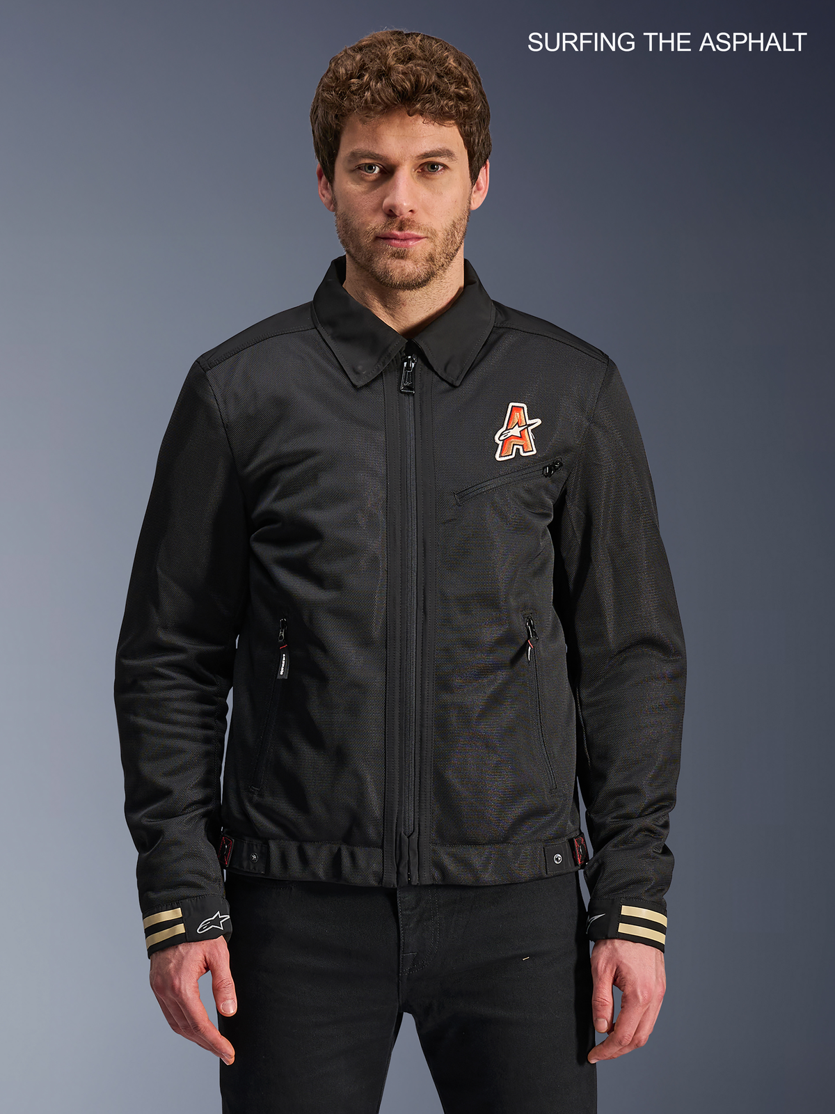 Alpinestars Kurtka Ignite Air, męska miejska motocyklowa kurtka tekstylna w kolorze czarnym, widok z przodu na model prezentujący tradycyjny kołnierzyk koszulowy, grafikę na klatce piersiowej inspirowaną stylem klubowym oraz certyfikowaną konstrukcję CE