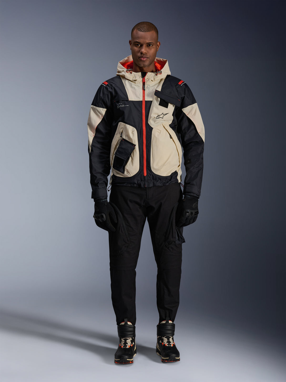 Alpinestars Mogress Air, męska tekstylna kurtka motocyklowa, czarna i kremowa z pomarańczowymi detalami.