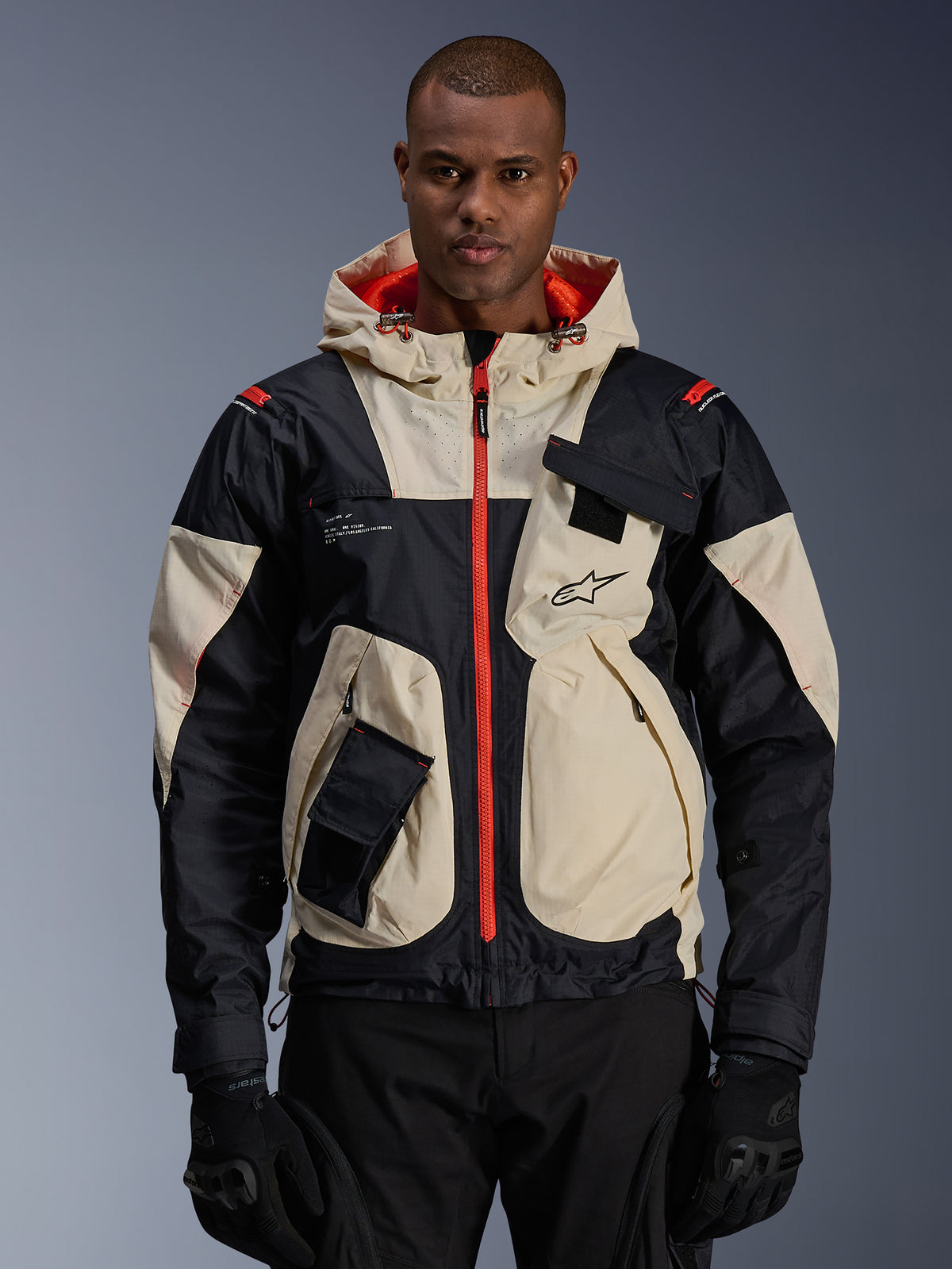 Alpinestars Mogress Air, męska miejska tekstylna kurtka motocyklowa, czarna i beżowa z jaskrawopomarańczowymi detalami.