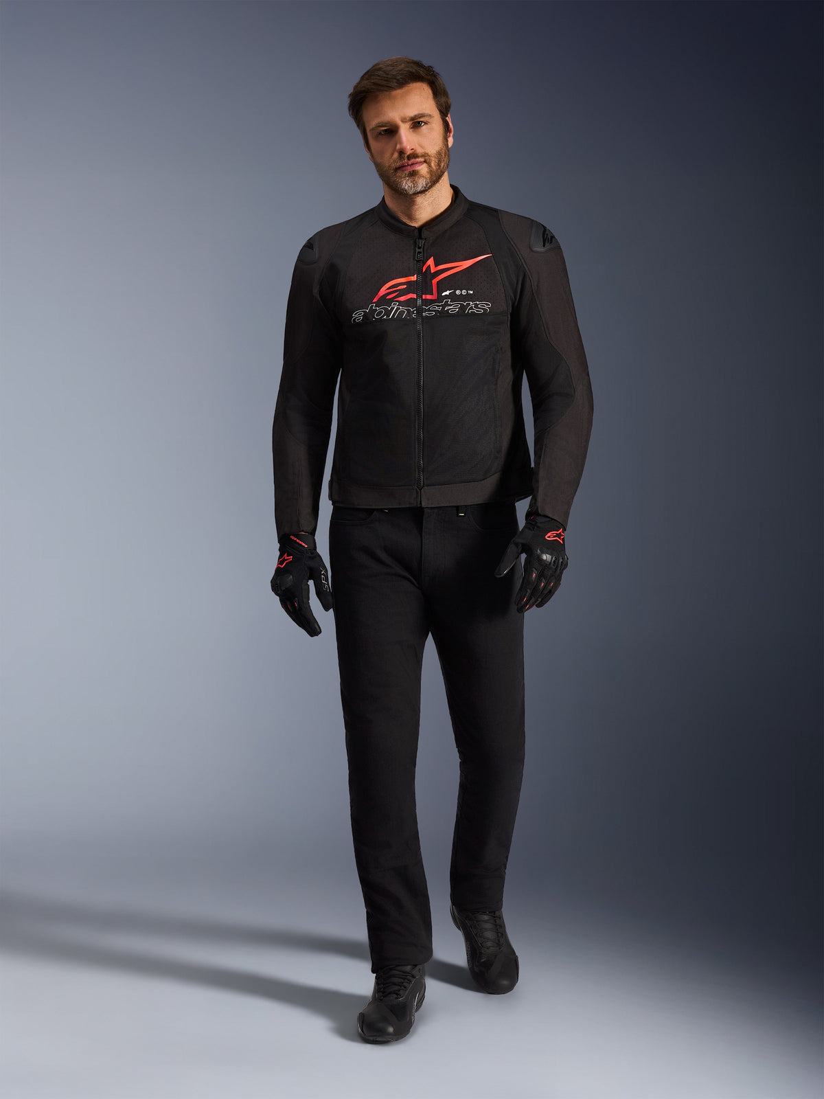 Alpinestars SMX Air Jacket, Black Bright Red and White, sport motorcycle jacket worn with black riding pants and gloves, featuring technical mesh panels and a bold red Alpinestars logo on the chest, performance street riding outfit