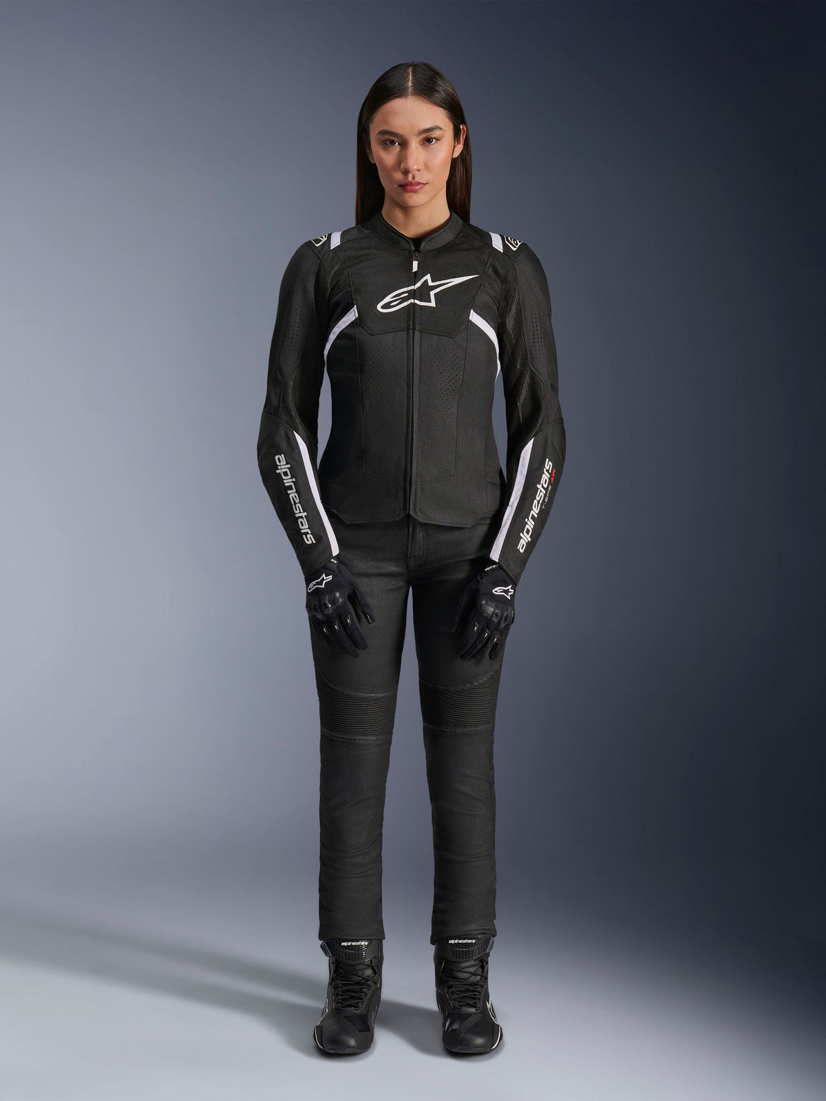 Alpinestars Stella T-Sps Air V2 Jacket, damska kurtka motocyklowa, czarno-biała, z panelami z siatki i białymi akcentami, noszona z czarnymi spodniami, rękawicami i butami, sportowy krój do jazdy miejskiej