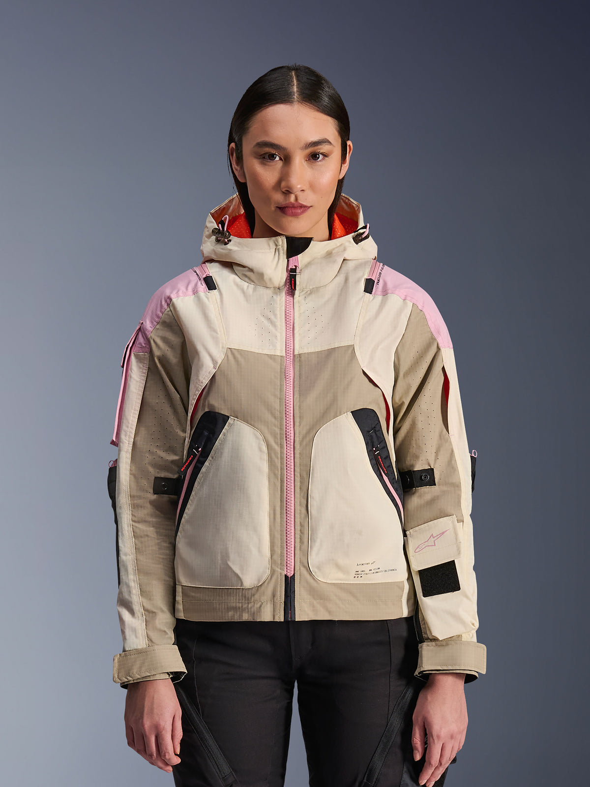 Alpinestars Molly Air Jacket, damska miejska kurtka motocyklowa w kolorystyce Sand Pink Almond, z kapturem, laserowo perforowaną wentylacją, różowym zamkiem i regulowanymi paskami na rękawach, pokazana na modelce