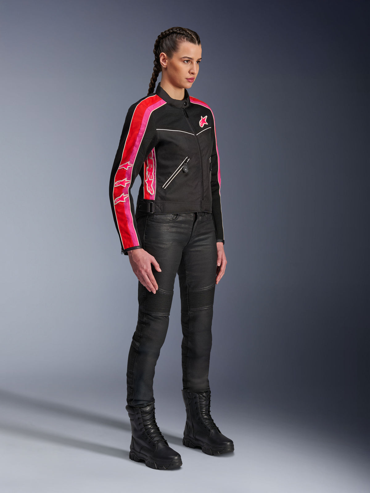 Alpinestars Stella T-Dyno Air Jacket, damska kurtka motocyklowa, czarna z jaskrawoczerwonymi i fuksjowymi pasami na rękawach, zestawiona z czarnymi spodniami i butami motocyklowymi, inspirowany stylem vintage design z siatki do jazdy miejskiej