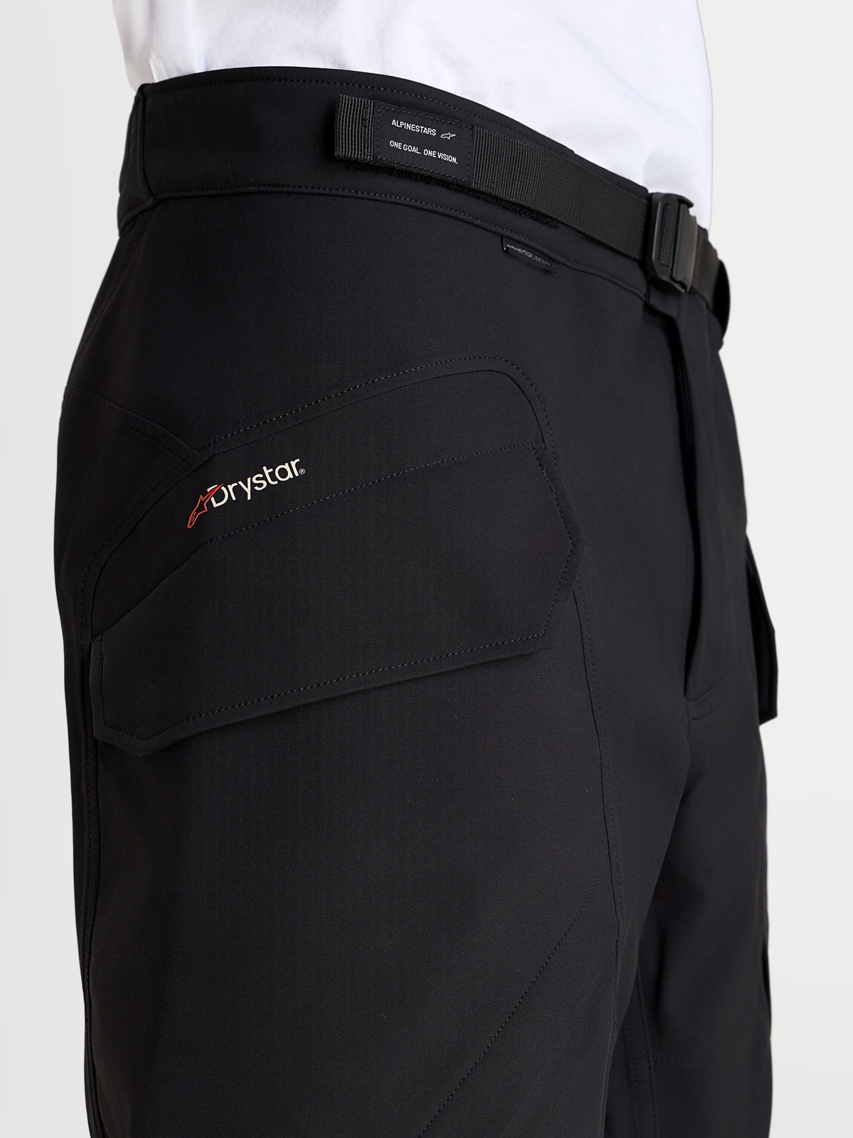 Alpinestars Juggernaut V2 Drystar spodnie motocyklowe miejskie męskie, czarne, zbliżenie na logo Drystar, kieszeń typu cargo i regulowany pas z klamrą magnetyczną