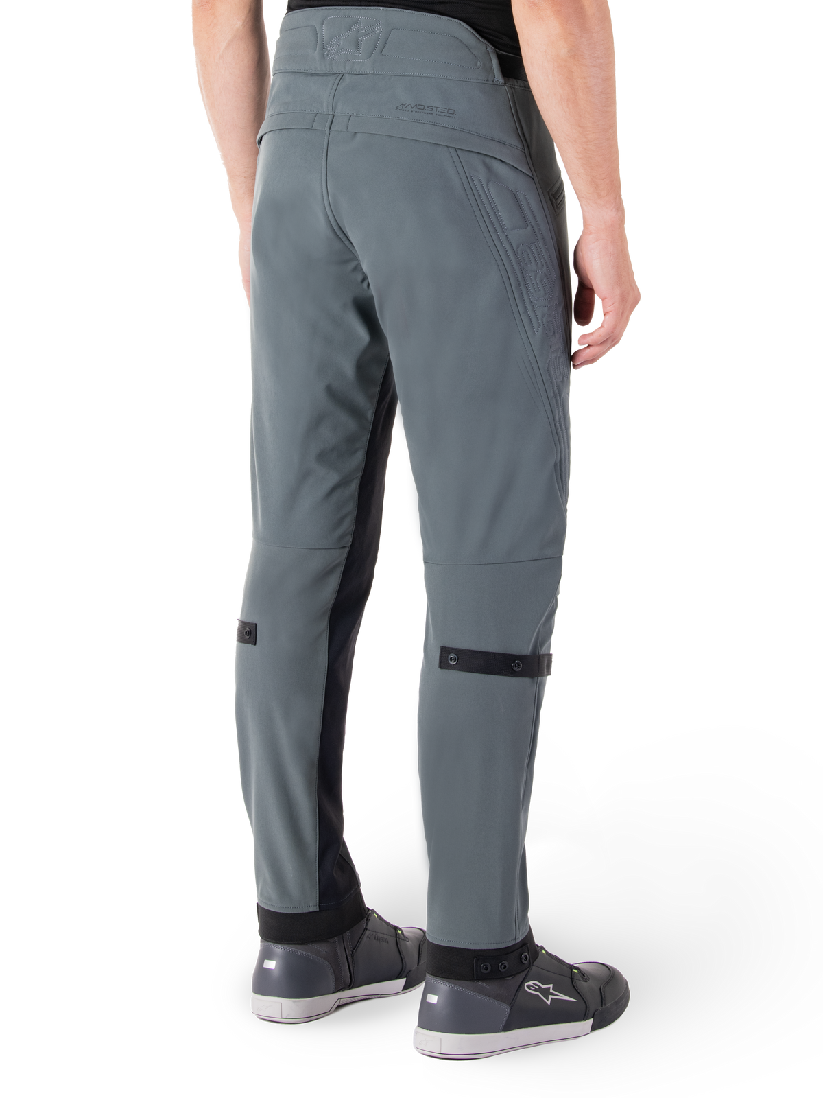 Spodnie Alpinestars Alden, Urban Gray, widok z boku od tyłu, techniczne spodnie motocyklowe inspirowane streetwearem z pikowanymi detalami w talii i czarnymi paskami na łydkach, szare buty motocyklowe, nowoczesna miejska odzież motocyklowa