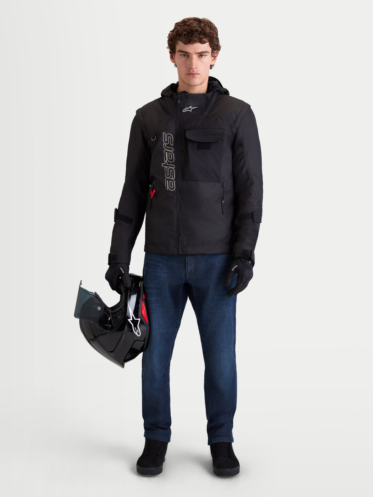 Alpinestars Flex-AST 10 Tough Max Denim Pants Short, men's urban motorcycle denim pants in dark blue, worn by a model along with a black motorcycle jacket and holding a helmet