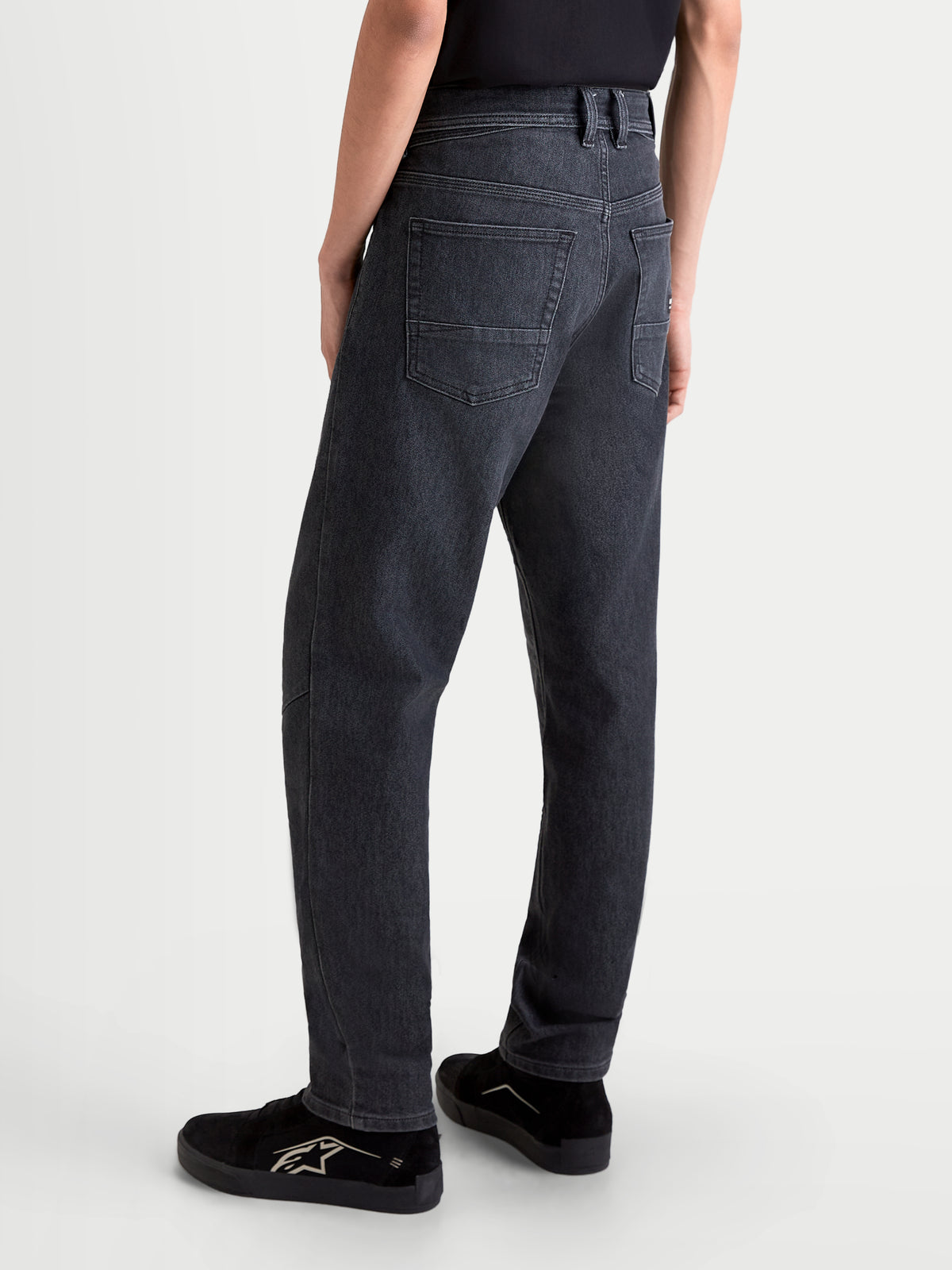 Alpinestars Flex-AST 7 Denim, męskie jeansy motocyklowe urban w spranym czarnym kolorze, widok z tyłu na konstrukcję z pojedynczej warstwy denimu, układ z pięcioma kieszeniami i wygodny regularny krój prezentowany na modelu