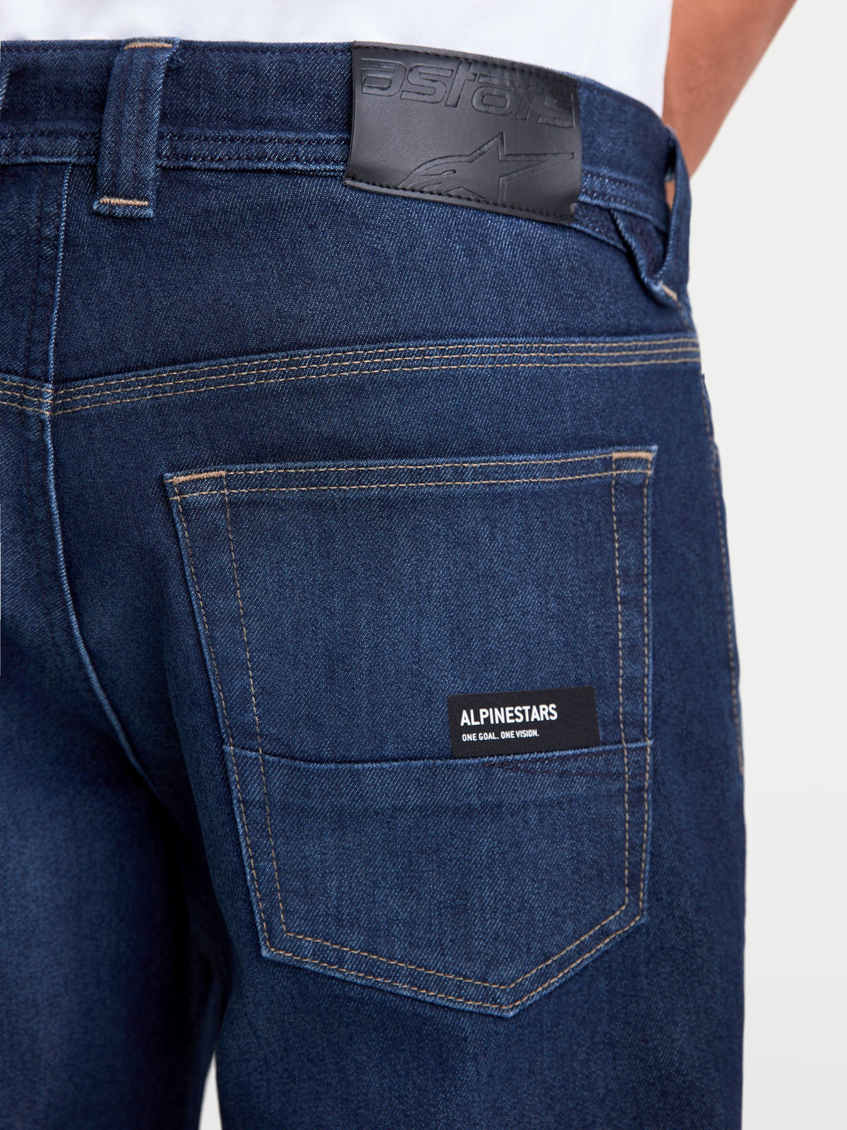 Alpinestars Flex Ast 7 Denim spodnie motocyklowe miejskie męskie w kolorze ciemnoniebieskim, zbliżenie tyłu pokazujące skórzaną naszywkę na pasie, tylne kieszenie z logo Alpinestars oraz certyfikowaną jednowarstwową konstrukcję klasy AA