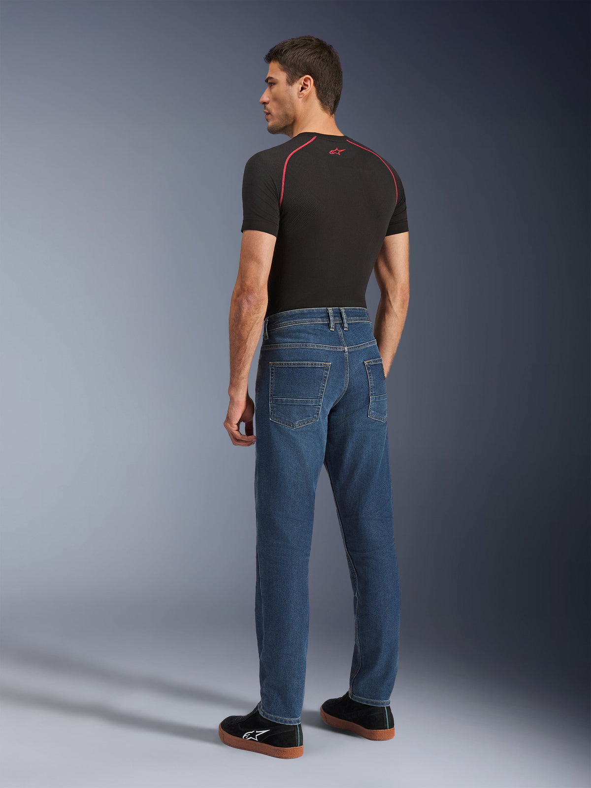 Alpinestars Flex-AST 5 Denim Pants, Indigo Washed, back view of model wearing the pants, urban motorcycle riding jeans, tapered fit with monolayer stretch denim, paired with a black t-shirt and black sneakers