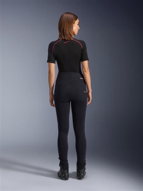 Legginsy Alpinestars Stella Flex-Ast, damskie legginsy motocyklowe, czarne, widok z tyłu prezentujący dopasowany krój z wysokim stanem, zestawione z czarną koszulką z krótkim rękawem i czarnymi butami motocyklowymi, miejska odzież motocyklowa