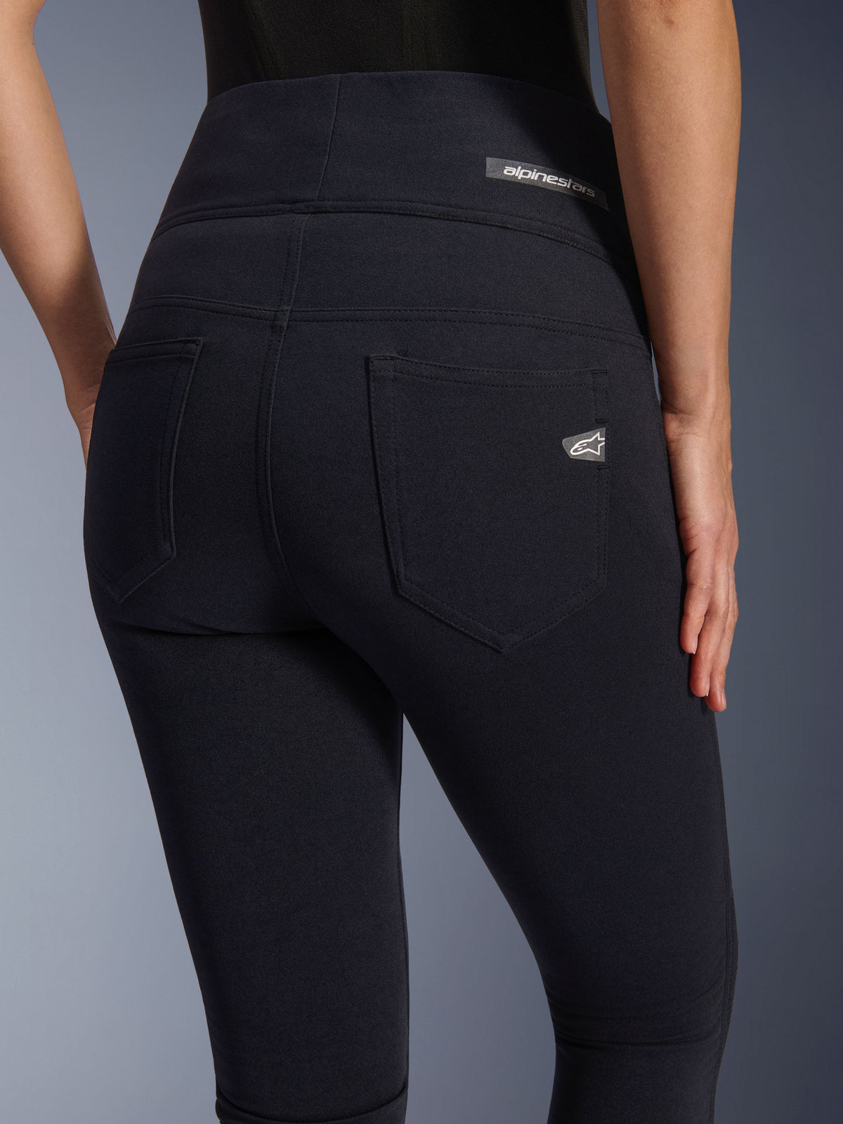Alpinestars Stella Flex-Ast Leggings, damskie legginsy motocyklowe, czarne, widok z tyłu prezentujący wysoki stan, dwie tylne kieszenie, logo Alpinestars na pasie i prawej kieszeni, dopasowany materiał do jazdy miejskiej