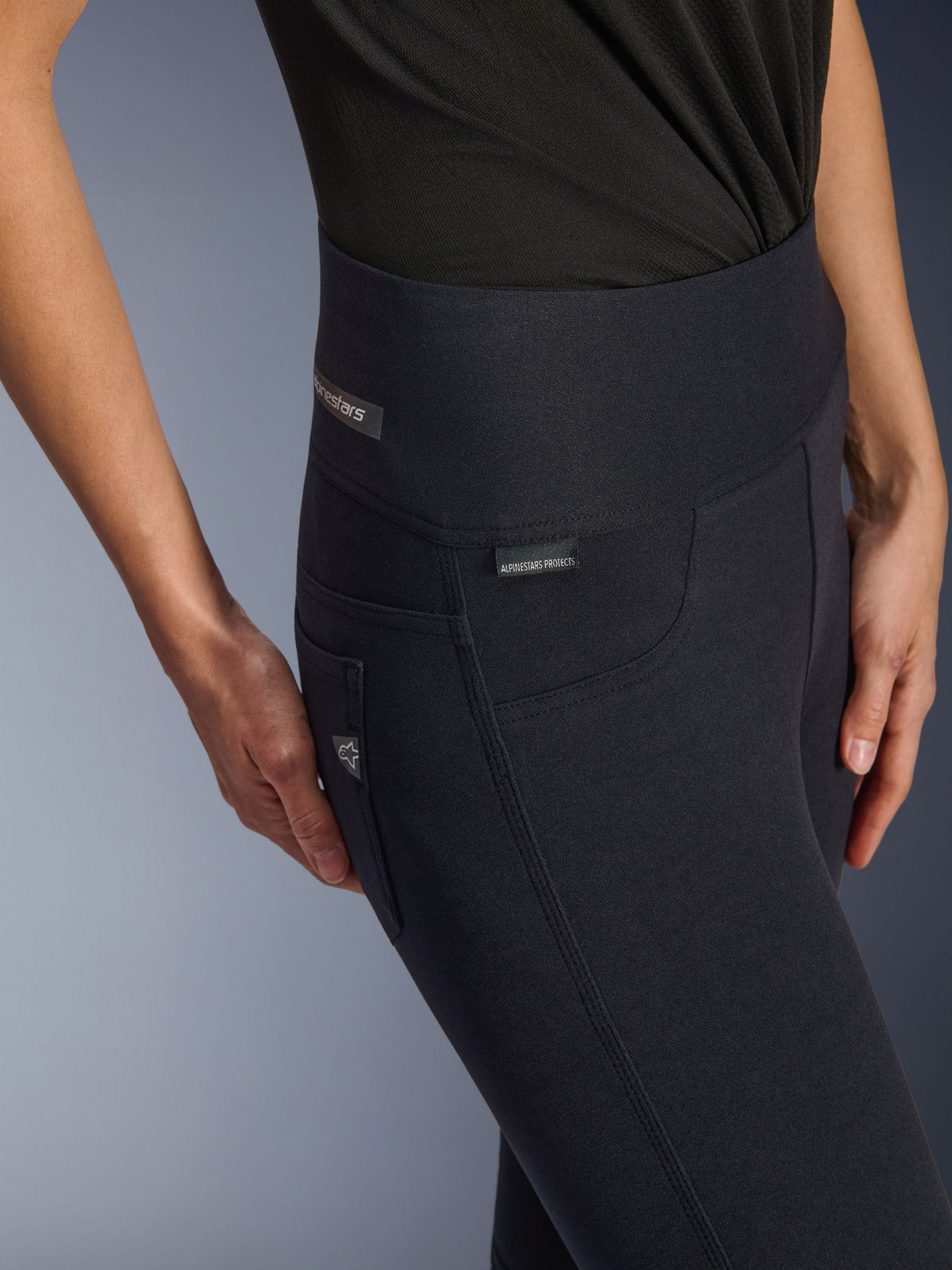 Alpinestars Stella Flex-Ast Leggings, damskie legginsy motocyklowe, czarne, zbliżenie na wysoki stan i okolicę bioder z subtelnymi oznaczeniami marki, stylowy miejski design do jazdy szosowej
