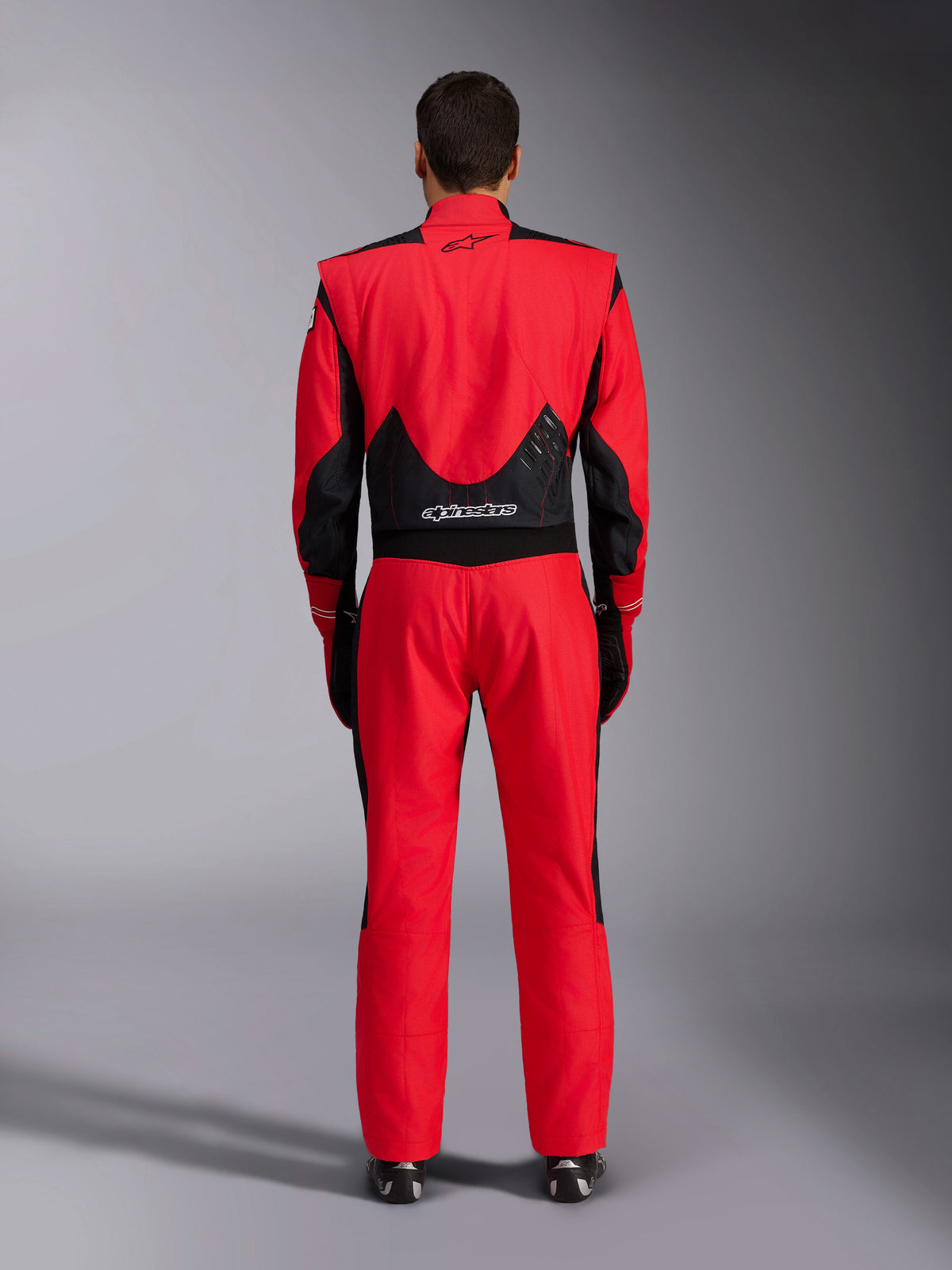 Alpinestars GP Pro Comp V2 FIA Racing Suit, Red and Black, back view showing black mesh and stretch panels on the lower back, Alpinestars branding on the upper and lower back, professional auto racing gear