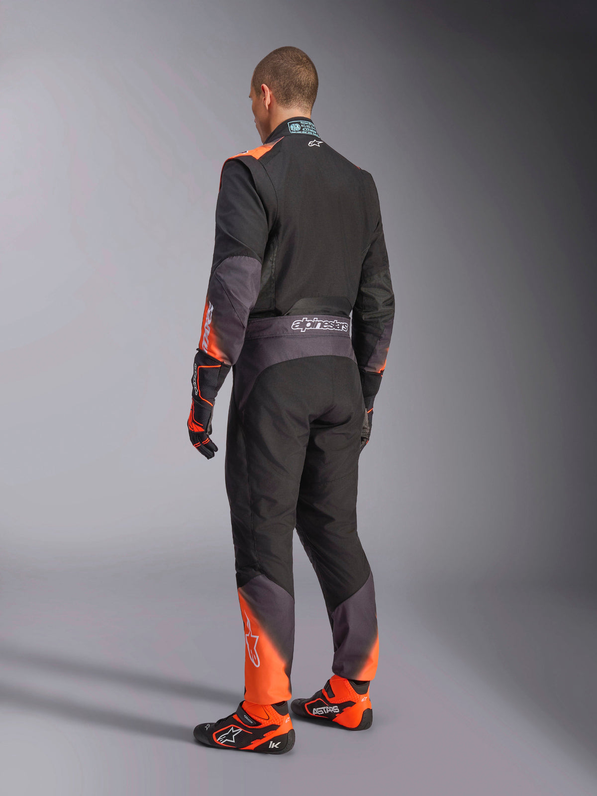 Kombinezon Alpinestars KMX-5 V3, męski kombinezon kartingowy, widok z tyłu, czarny i pomarańczowy fluo, FIA 8877-2022 klasa 1.