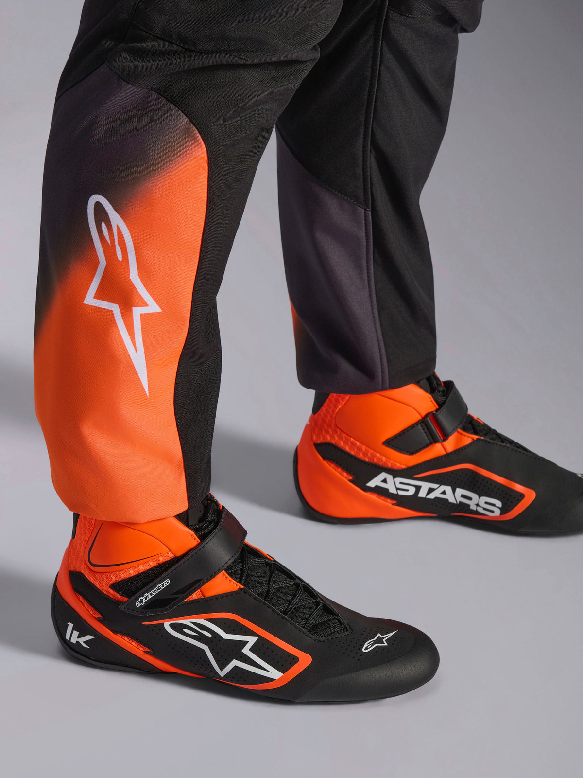 Kombinezon Alpinestars KMX-5 V3, męski kombinezon kartingowy, czarny i pomarańczowy fluo, FIA 8877-2022, nogawki i buty.