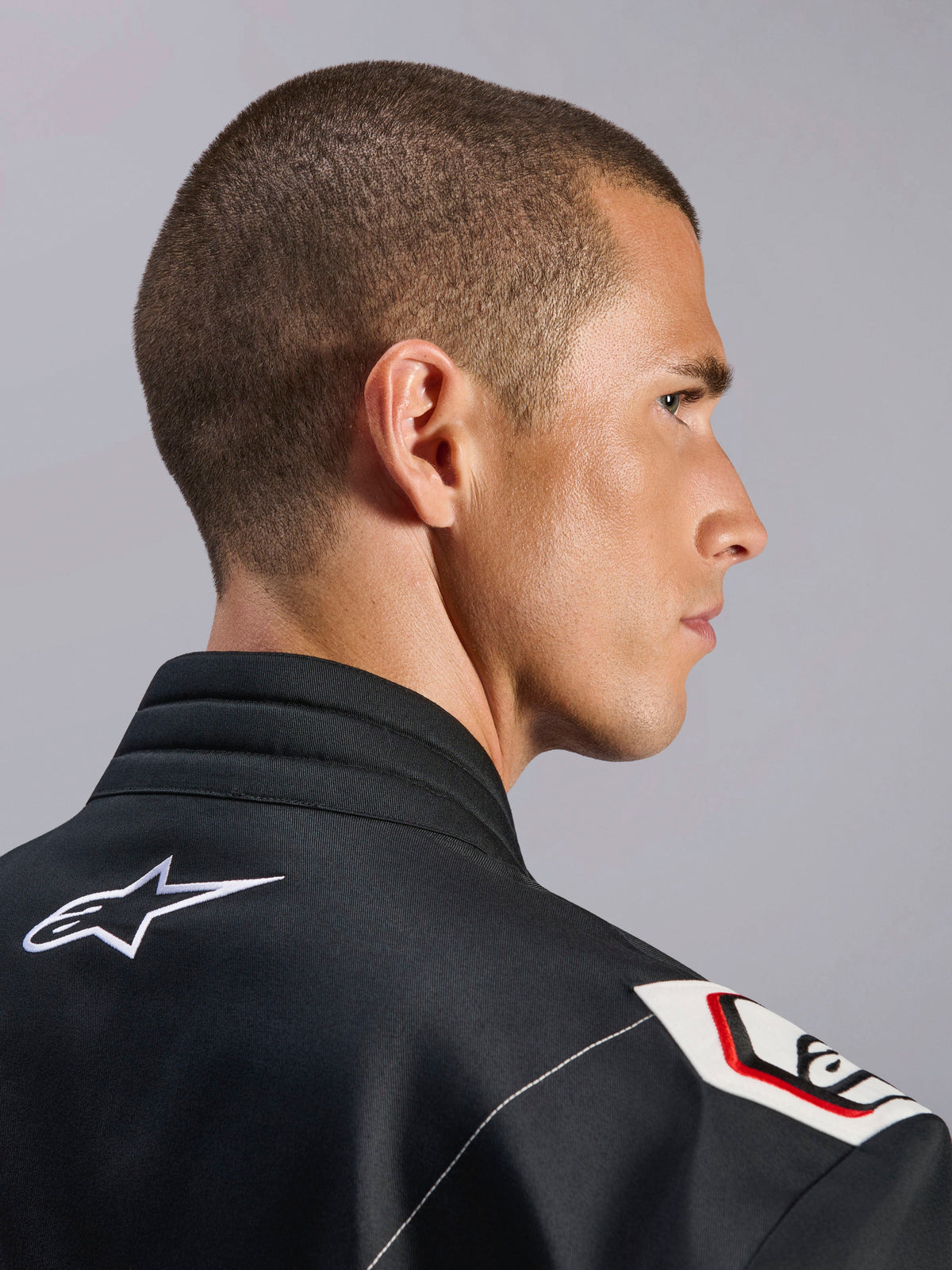 Alpinestars Kart Indoor V2 Suit, Black, close-up view of the ergonomic collar and Formula 1-derived shoulder design, featuring white Alpinestars logo and racing-inspired details on durable twill fabric