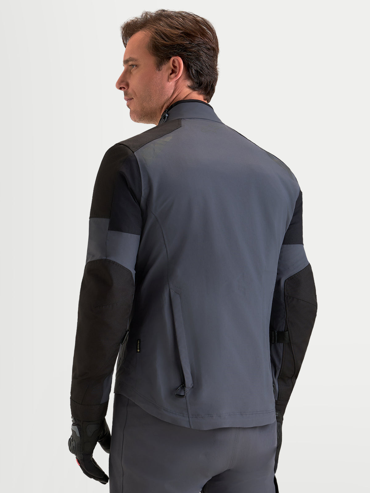 Alpinestars Arenis Gore-Tex® Jacket, men's adventure touring motorcycle jacket in black and deep gray, rear profile view showing waterproof textile construction and ergonomic collar.