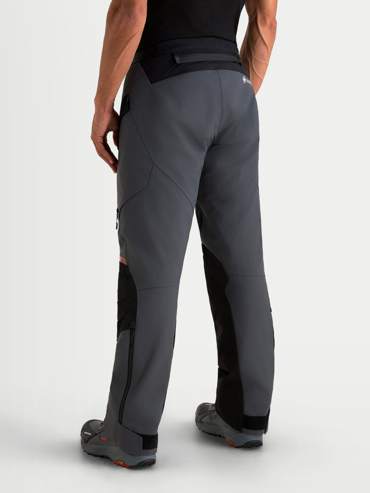 Alpinestars St 7 V 2 2 L Gore Tex Spodnie motocyklowe turystyczne męskie, ciemnoszare i czarne, widok z tyłu na model prezentujący wodoodporną konstrukcję tekstylną i wzmocnioną część siedziska
