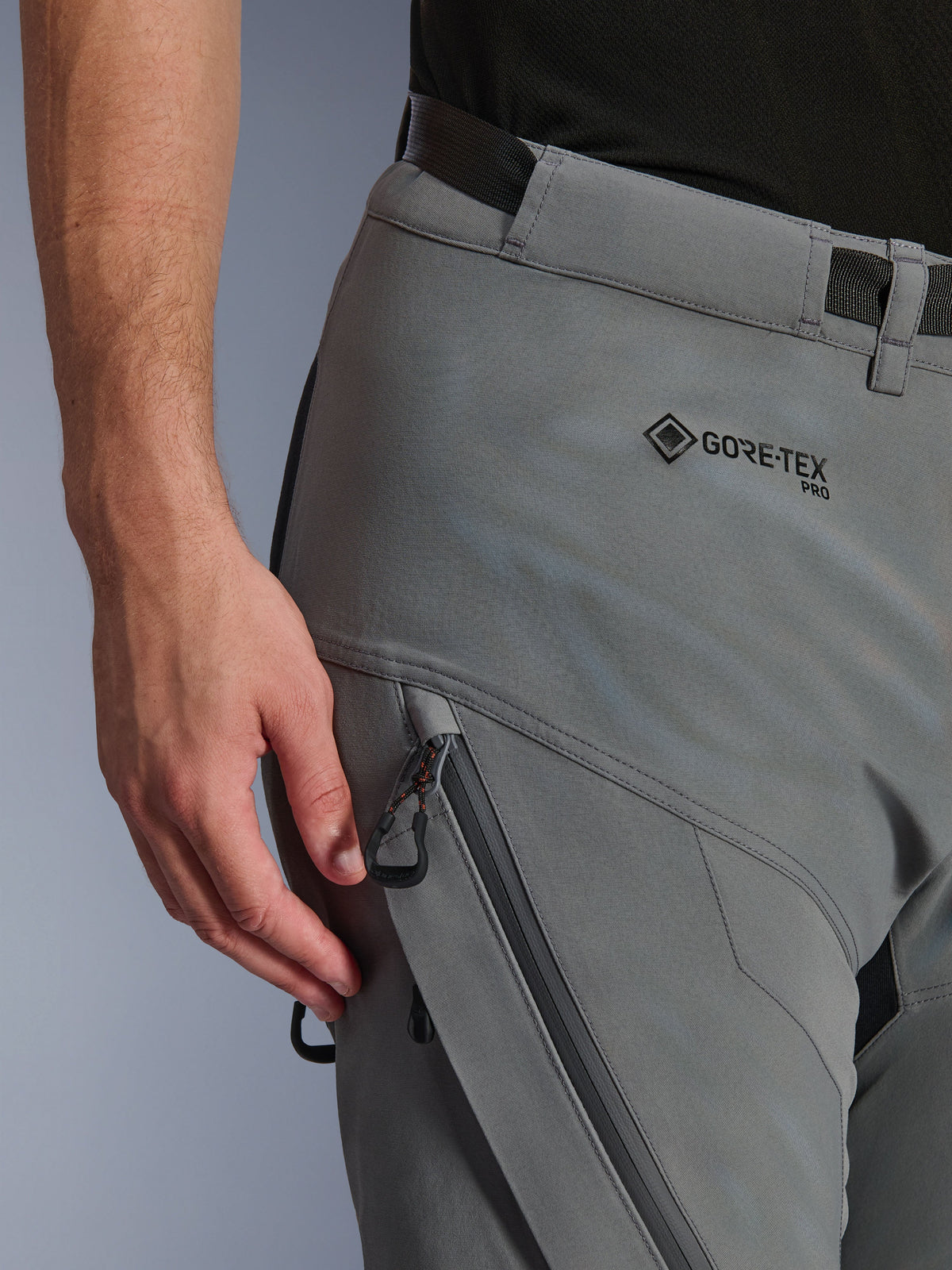 Zbliżenie na spodnie Alpinestars Nazca 3L GORE-TEX PRO w kolorze Dark Gray Black, pokazujące logo GORE-TEX PRO na biodrze, wodoodporną kieszeń cargo zapinaną na zamek oraz wytrzymałą konstrukcję tekstylną do jazdy adventure.