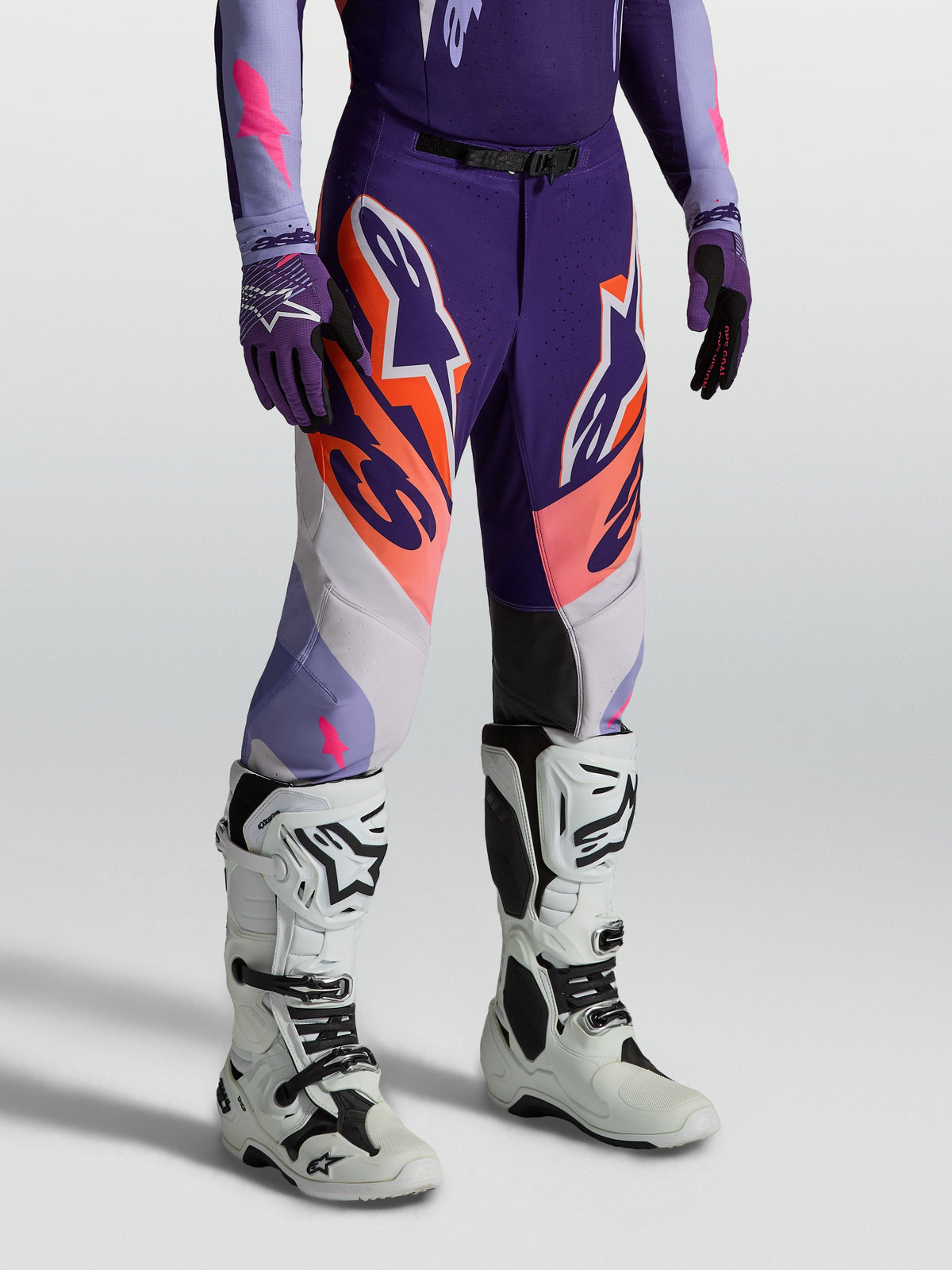 Spodnie Alpinestars Supertech Dyna, fioletowe i różowe fluo męskie spodnie motocrossowe o sportowym kroju wyścigowym.