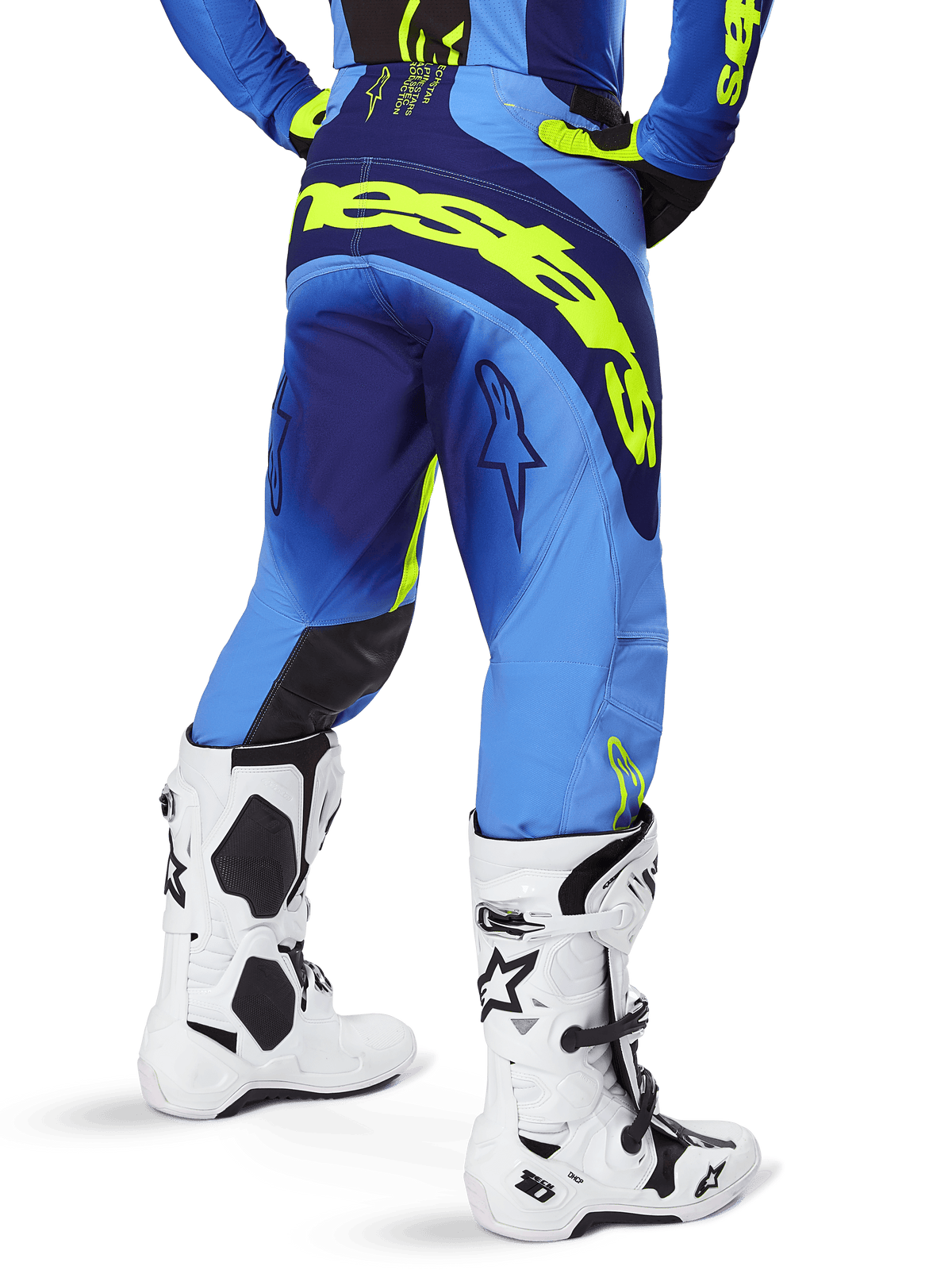 Alpinestars Techstar Melt Pants 2025, spodnie motocrossowe, żółty fluo niebieski, widok z tyłu z dużym żółtym brandingiem na siedzeniu i ciemnoniebieskimi akcentami, noszone z białymi butami Alpinestars Tech 10 i pasującą koszulką.