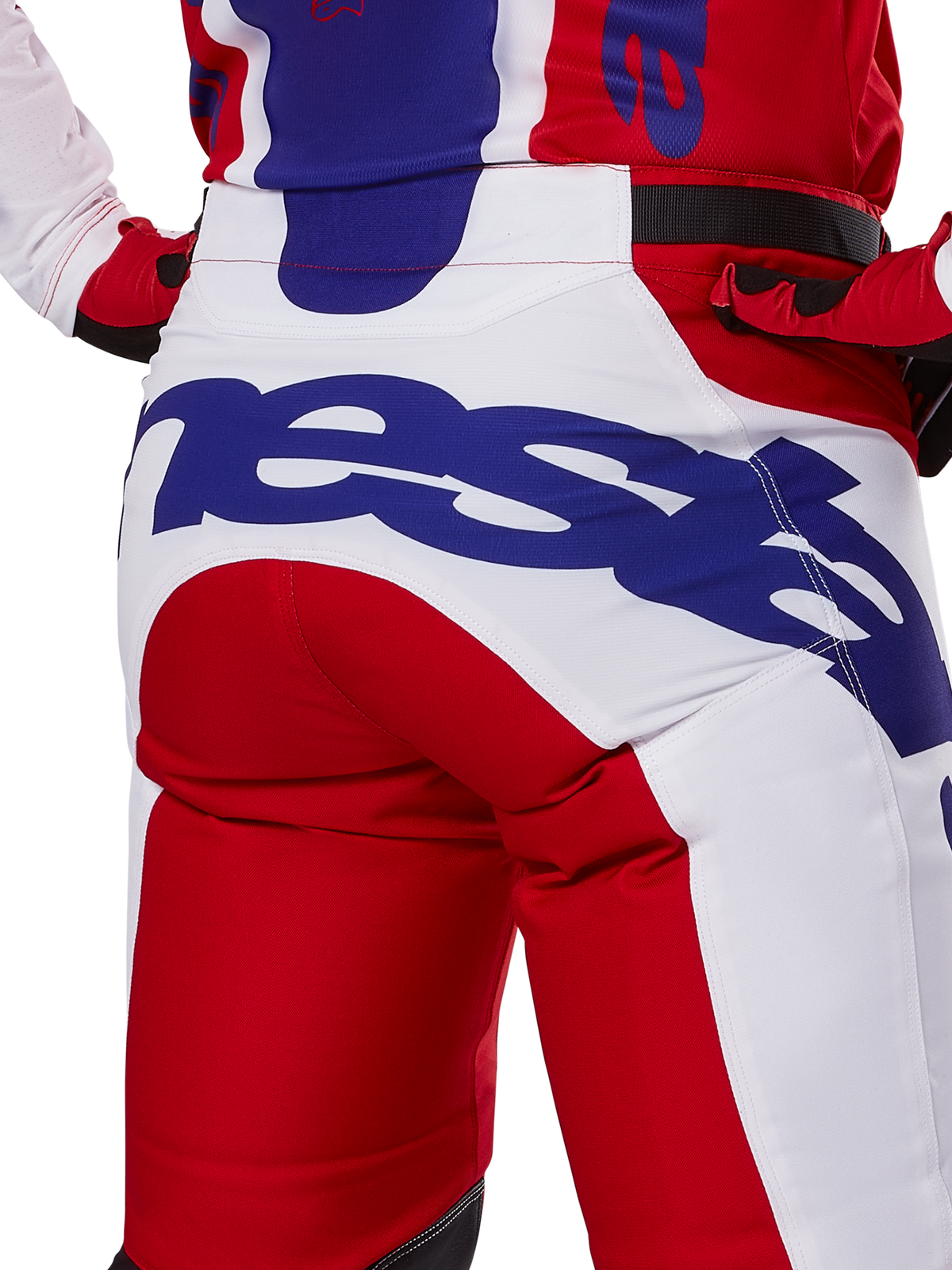 Alpinestars Racer Veil Pants 2025, spodnie motocrossowe, jaskrawoczerwone i białe z niebieskim brandingiem, widok z tyłu na detal siedziska z dużym logo Alpinestars, element dopasowanego stroju wyścigowego off-road