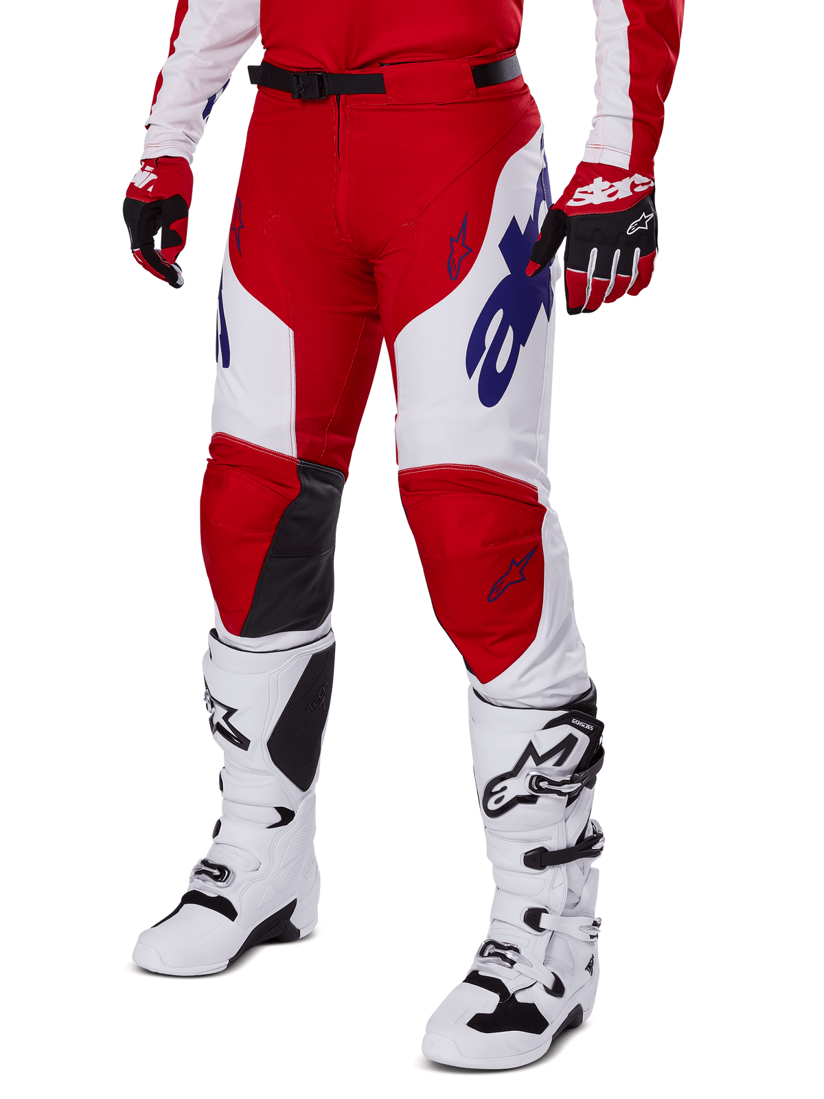 Spodnie Alpinestars Racer Veil 2025, spodnie motocrossowe, intensywnie czerwone i białe, z niebieskimi logo Alpinestars i czarnymi skórzanymi panelami na kolanach, zestawione z czerwonymi rękawicami i białymi butami motocrossowymi, skoordynowany komplet odzieży do wyścigów terenowych