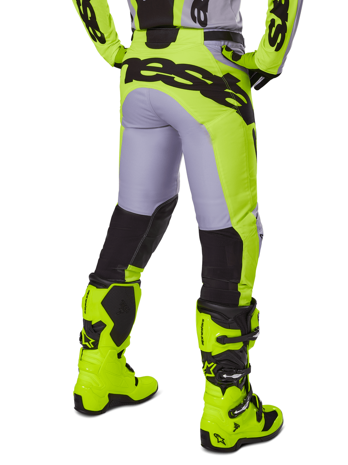 Alpinestars 2025 Racer Veil Pants, spodnie motocrossowe, szare i żółte neonowe, widok z tyłu przedstawiający ergonomiczną konstrukcję z dużym czarnym logo na siedzeniu, czarne panele na dole nogawek i pasujące jaskrawożółte buty wyścigowe