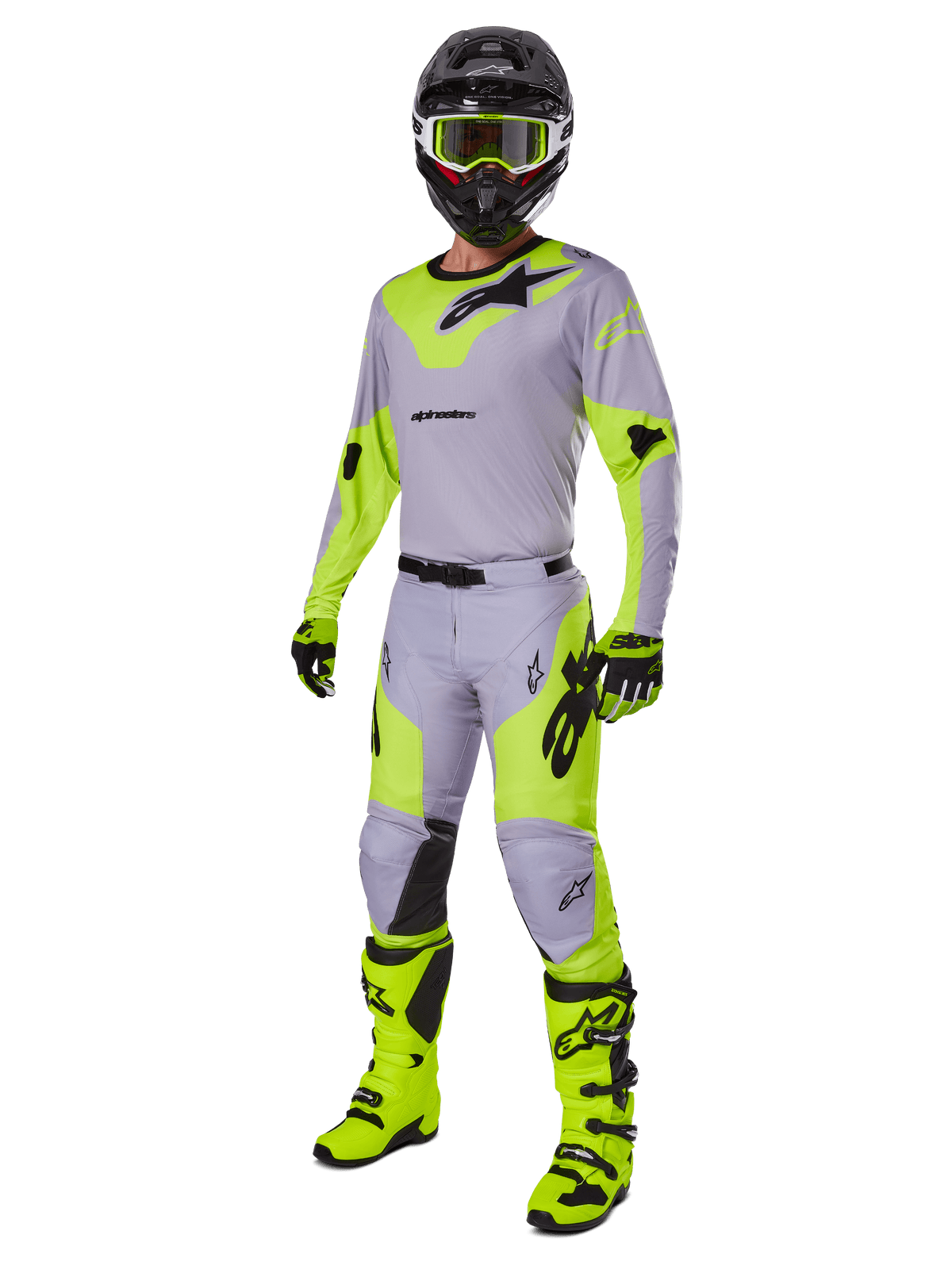 Alpinestars Racer Veil Pants 2025, spodnie motocrossowe, szare i żółte fluo, noszone z pasującą koszulką, czarnym kaskiem, żółtymi goglami fluo, butami i rękawicami, skoordynowany strój do wyścigów terenowych z wyrazistym brandingiem i ergonomicznym designem.