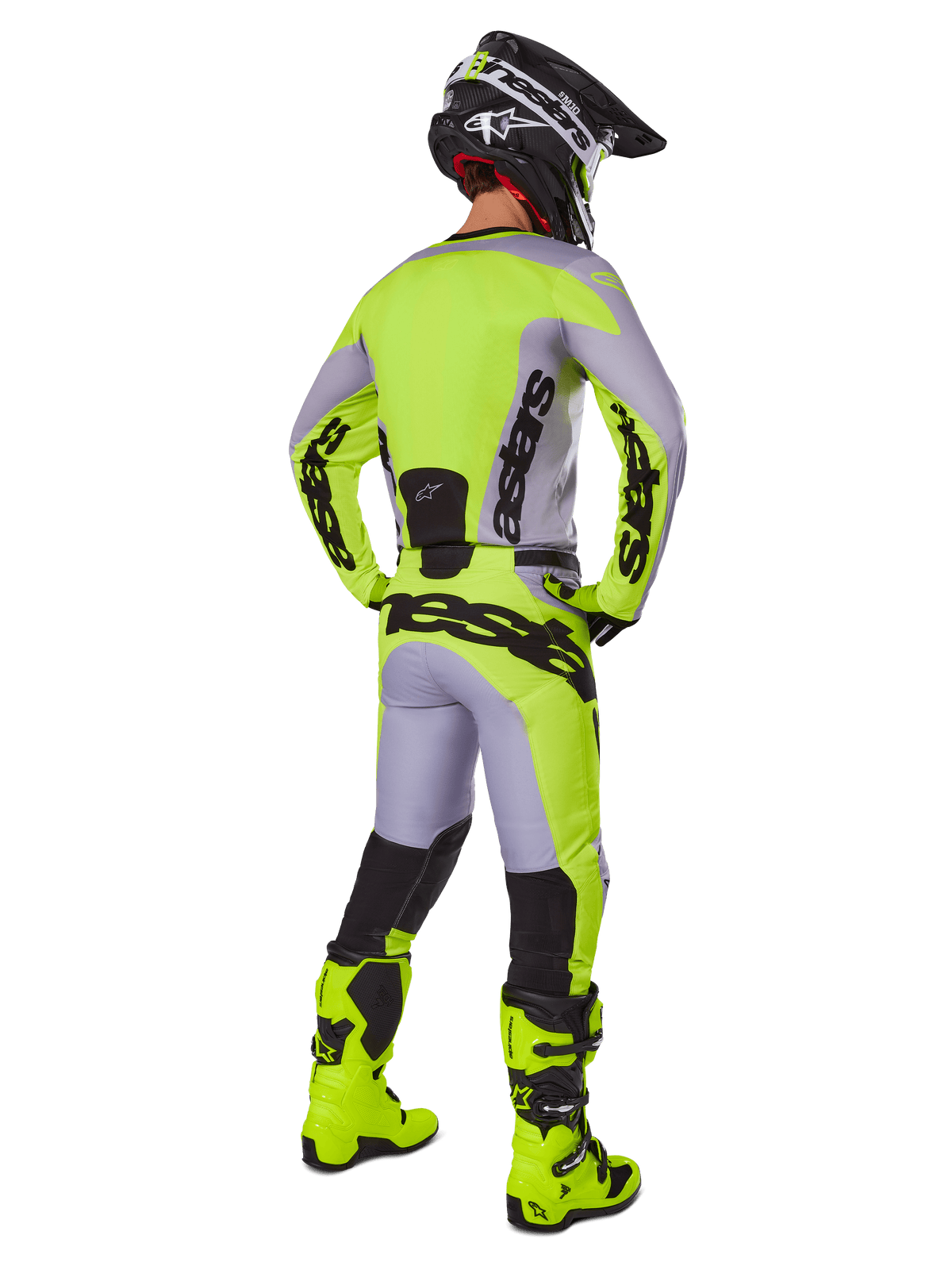 Alpinestars 2025 Racer Veil Pants, spodnie motocrossowe, szare i żółte fluorescencyjne, widok z tyłu zawodnika w pełnym stroju, pasująca bluza i żółte neonowe buty, wyraźne czarne logo, techniczny zestaw do wyścigów terenowych