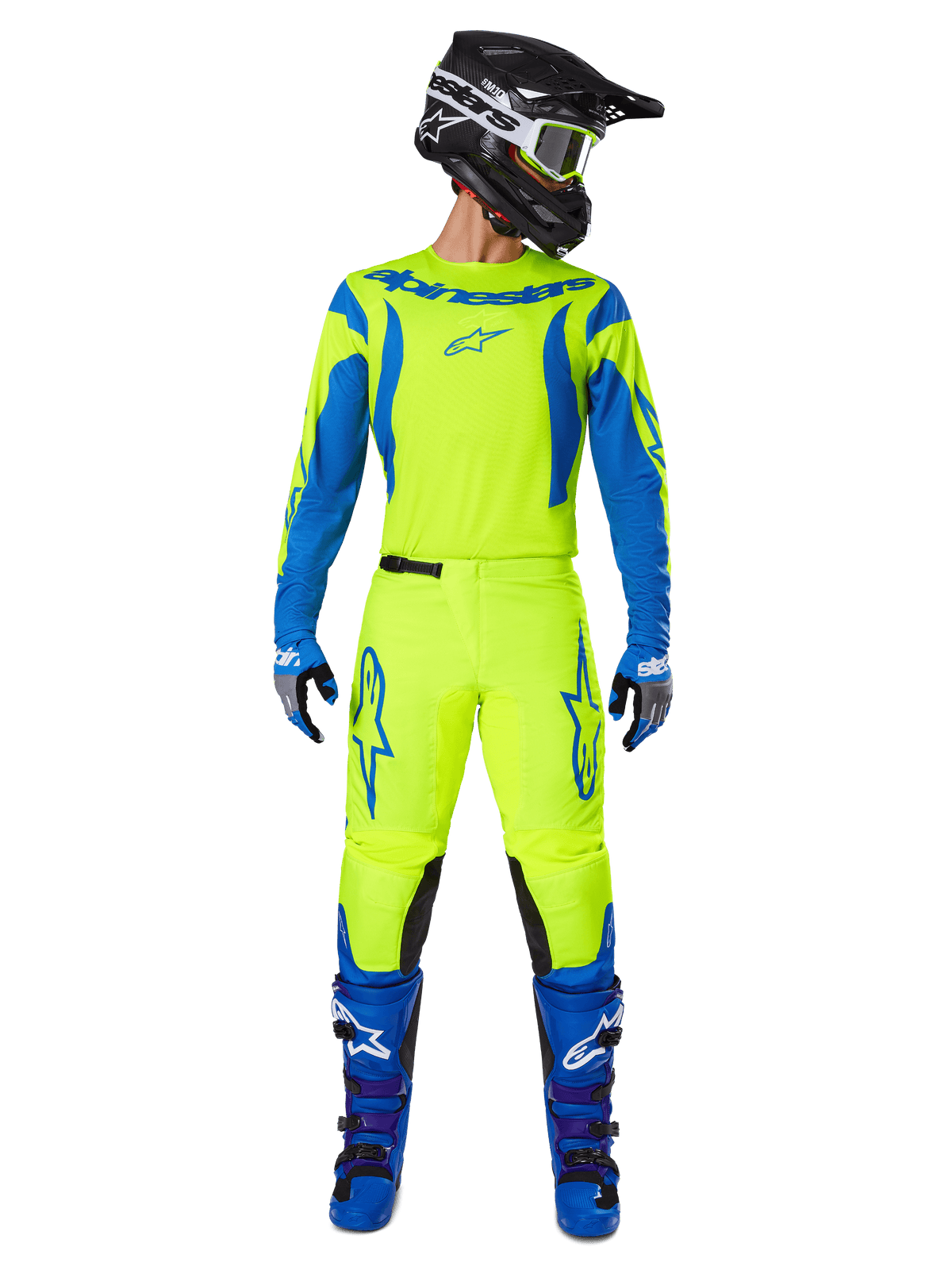 Alpinestars 2025 Fluid Haul Pants, spodnie motocrossowe, fluorescencyjny żółty i niebieski, noszone jako kompletny zestaw wyścigowy z pasującą koszulką, niebieskimi butami i czarnym kaskiem, z wyraźnym niebieskim brandingiem na udach i czarnymi panelami na kolanach