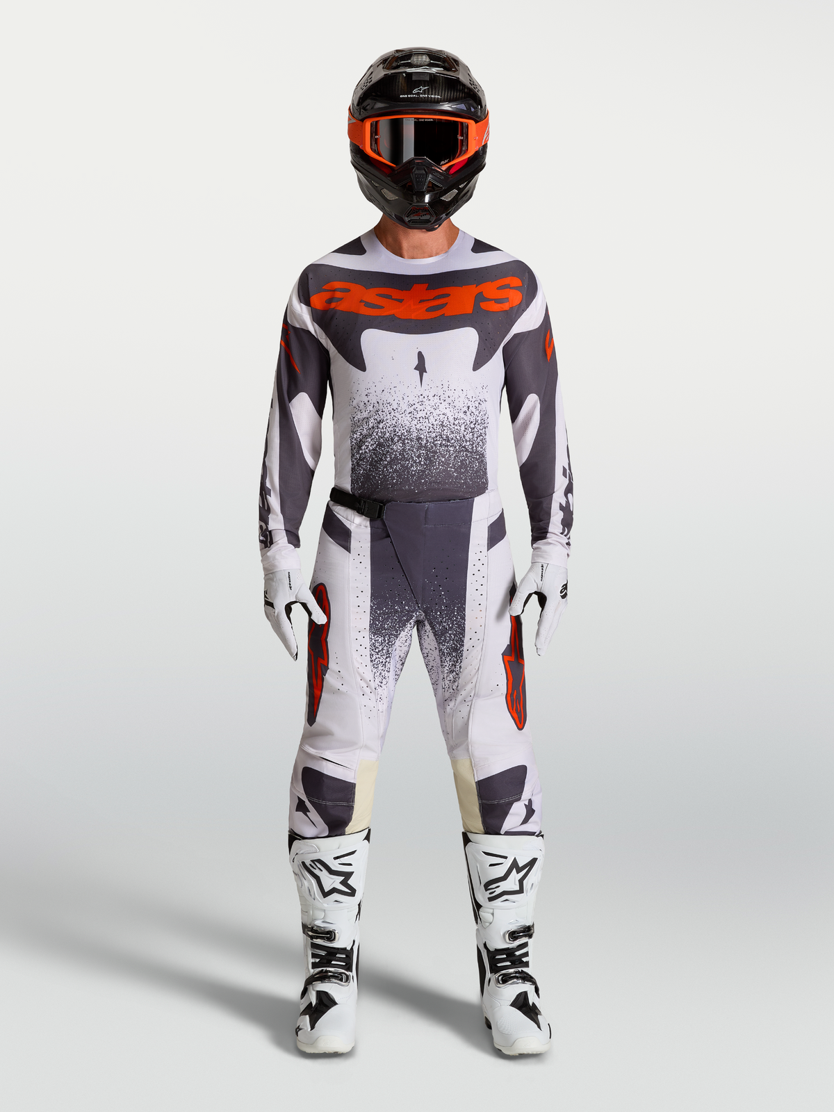 Alpinestars Techstar Swan, męski zestaw motocrossowy, jasnoliliowy i ciemnoszary z czerwonym fluo, białe buty wyścigowe.