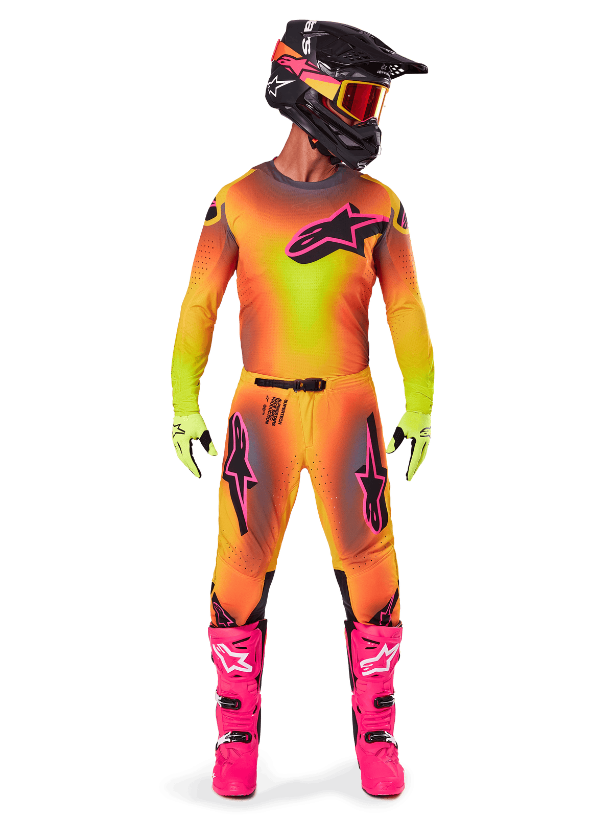 Strój motocrossowy Alpinestars 2025 Supertech Lipan, zawodnik w pełnym zestawie, wyrazisty żółto-różowy gradientowy wzór, koszulka z długim rękawem, jaskraworóżowe buty, limonkowe rękawice, czarny kask z pomarańczowymi goglami