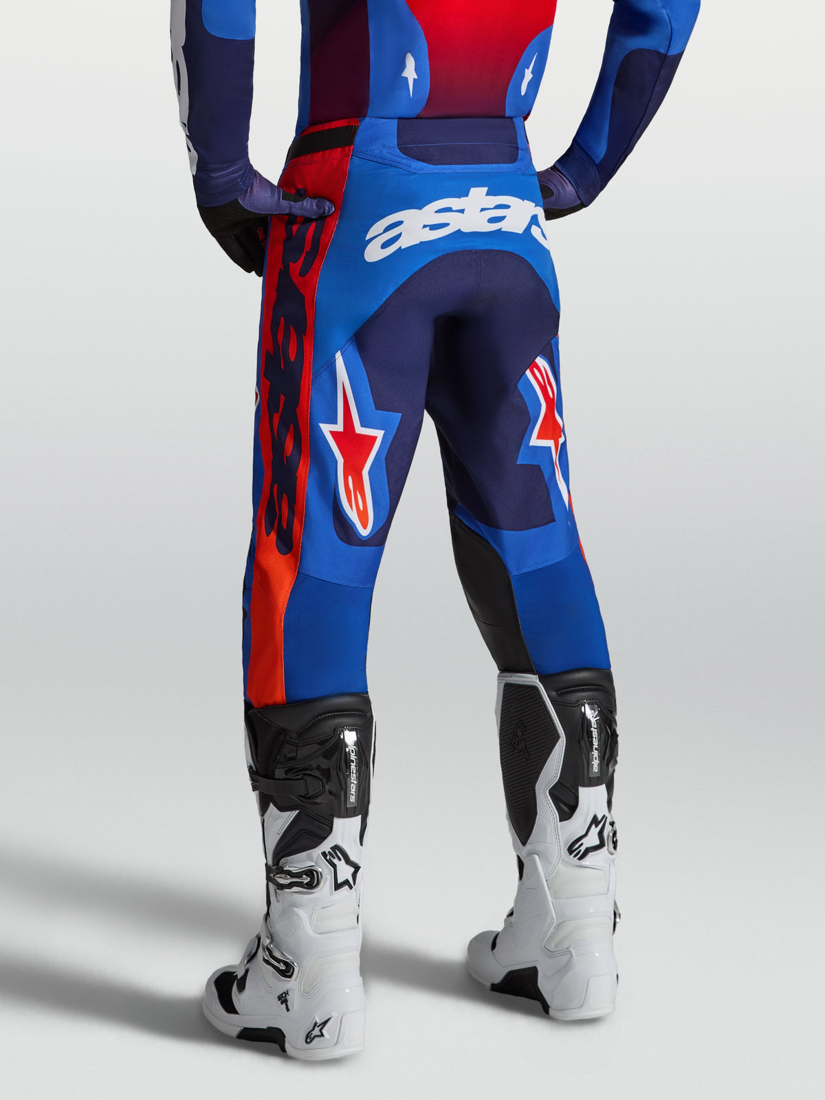 Alpinestars Spodnie Racer Hunt, męskie spodnie motocrossowe, niebieskie i czerwone z białym logo, widok z tyłu na modelu, ergonomiczny krój do jazdy off-road.
